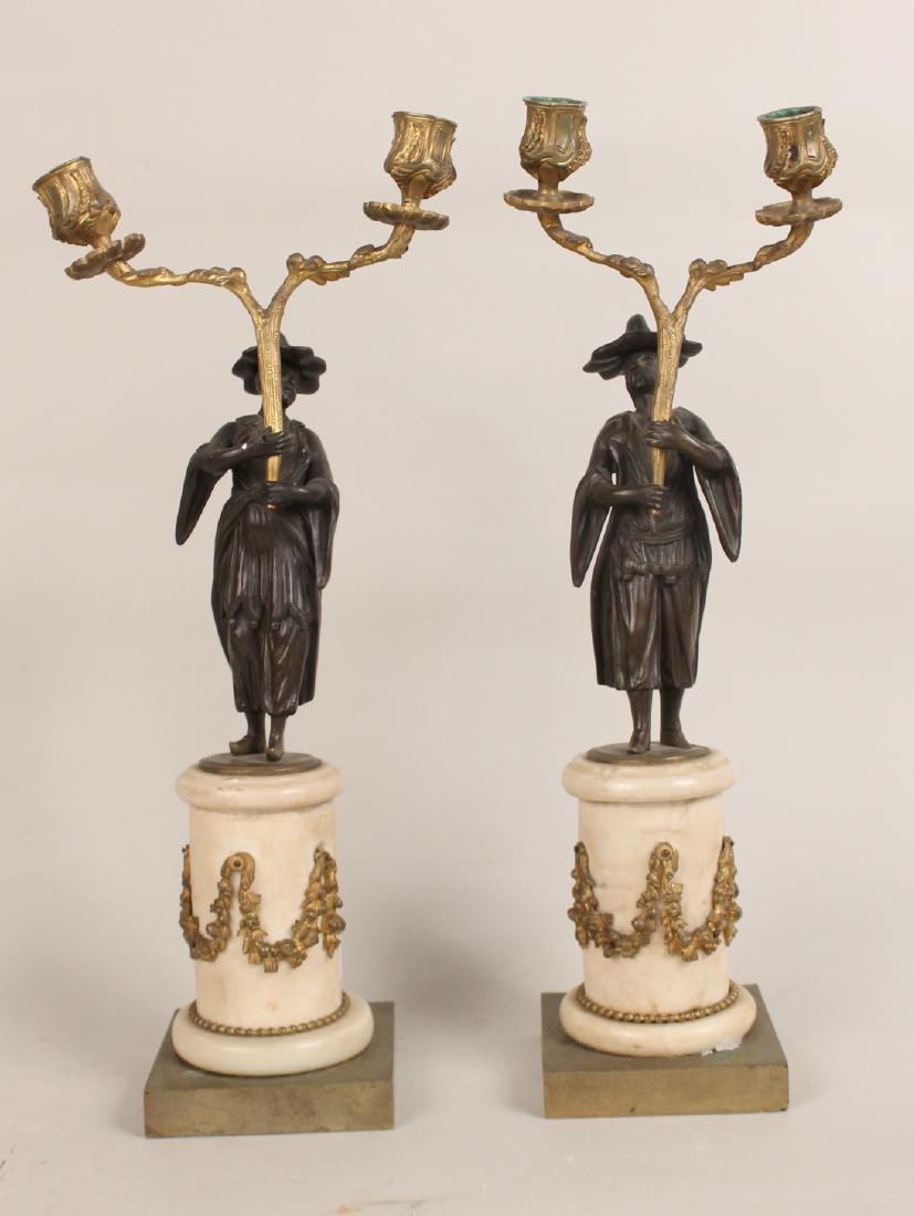 Pair of Patinated and Gilt Metal Two Light: Candelabra, 18th century Asian dressed figures on cylindrical marble bases with ormolu swag mounts. 17"h x 7"w.