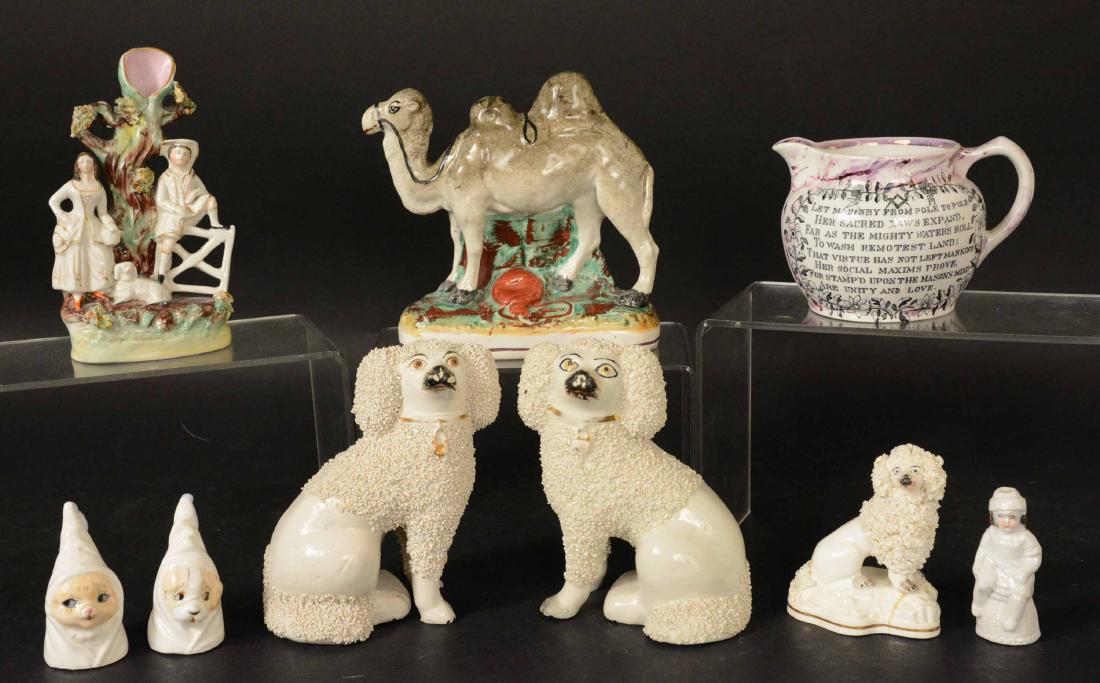 Six Staffordshire Porcelain Figures: England. Comprising a pair of Spaniel dogs, a miniature spaniel dog, a camel, a baker figure and a figural group depicting peasants and a dog. Together with a lustreware milk jug and a two bone china 