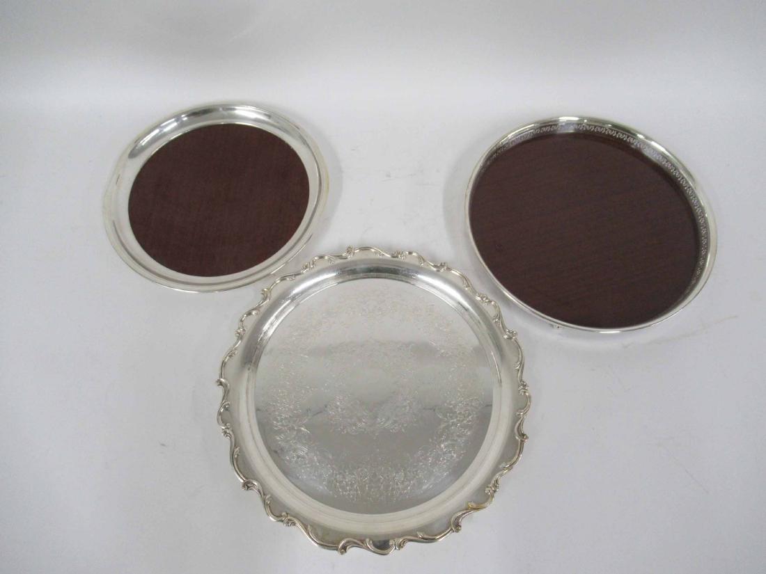 Two Silver Plated Mounted Circular Wooden: Trays. Together with a silver plated circular tray with shaped border. 12"d., 12-1/2"d, 14"d.