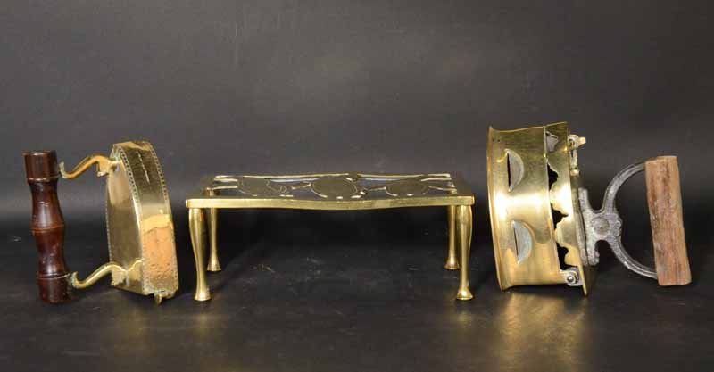 Two Brass Sad Irons: Together with a brass stand. 4 1/2"h x 12"l x 6"w