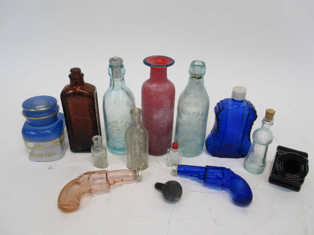 Group of Vintage Glass Bottles: Including a "Bicarb Soda" bottle and two pistol form bottles. 15 pieces. Tallest 7 1/2"h