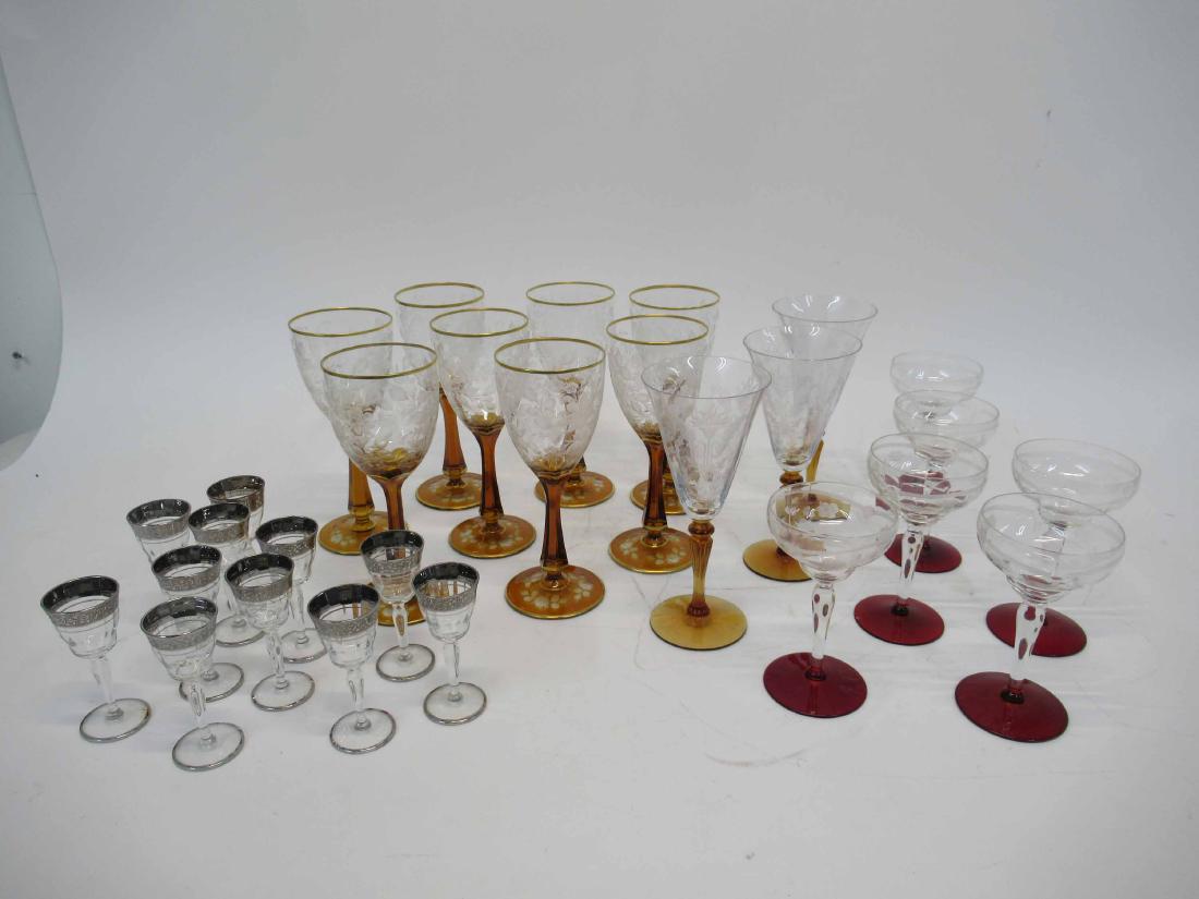 Group of Assorted Etched Glass and Color Stemwar: Including eight gilt rimmed and amber stem goblets, three amber stem wine glasses, six ruby glass footed champagne boats and a twelve silver rimmed cordial glasses. 29 pieces. Assorted.