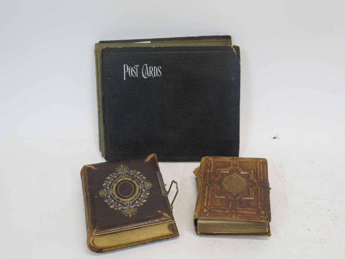 Vintage Photo Album: Leather bound gilt decorated case opening to first picture of Abraham Lincoln along with assorted family photographs and tin. Together with a similar album and postcard album. 6 1/2" x 6" x 2 3/8"