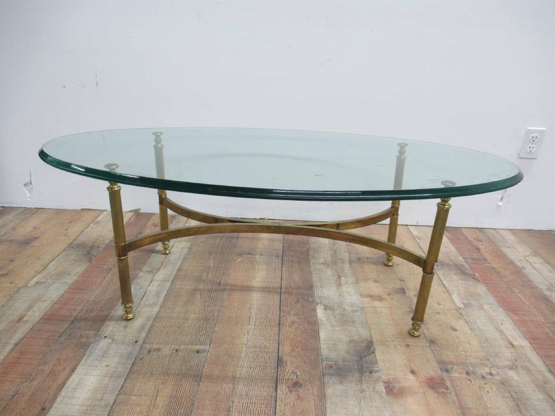 Modern Oval Glass Top Coffee Table: Glass top with brass base. 48" long x 24" wide x 16"tall