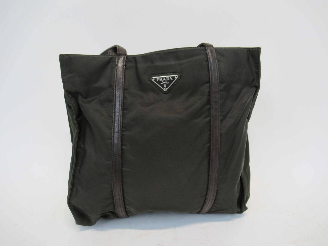 Prada Brown Nylon & Leather Tote Bag: Double long brown leather straps, interior with brown signature fabric, divided with zipper compartment, back wall with zipper compartment and metal plaque Prada Milano Made in Italy, front triangular