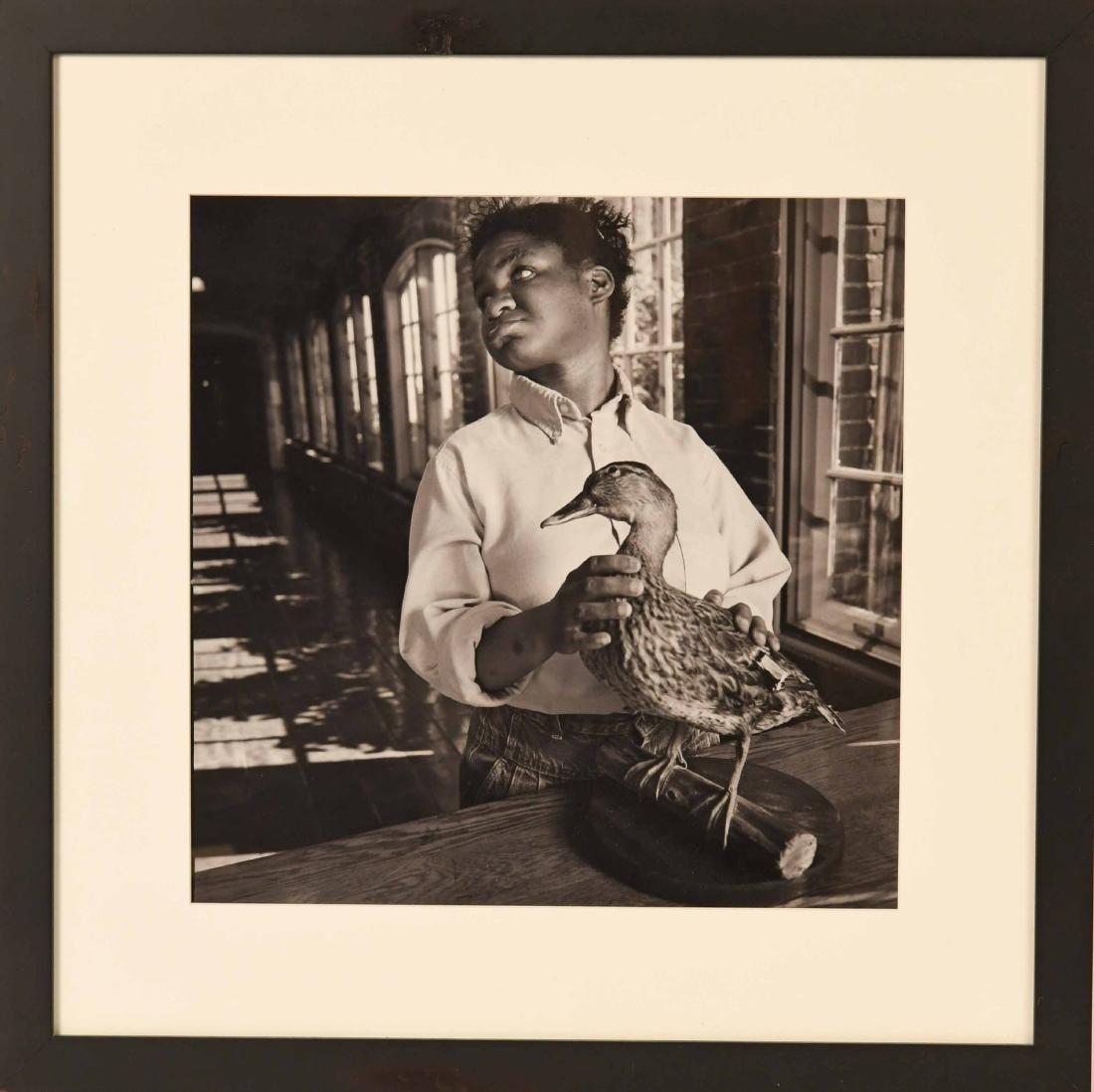 Gelatin Silver Print, Boy & Duck Mary Ellen Mark: (American, b. 1940), titled "Boy with Brown Duck" c. 1989, printed later, probably signed, dated and numbered from an edition of 25 in graphite to verso. Sight size: 14-3/4"h x 14-3/4"w on 20"h x 16"w