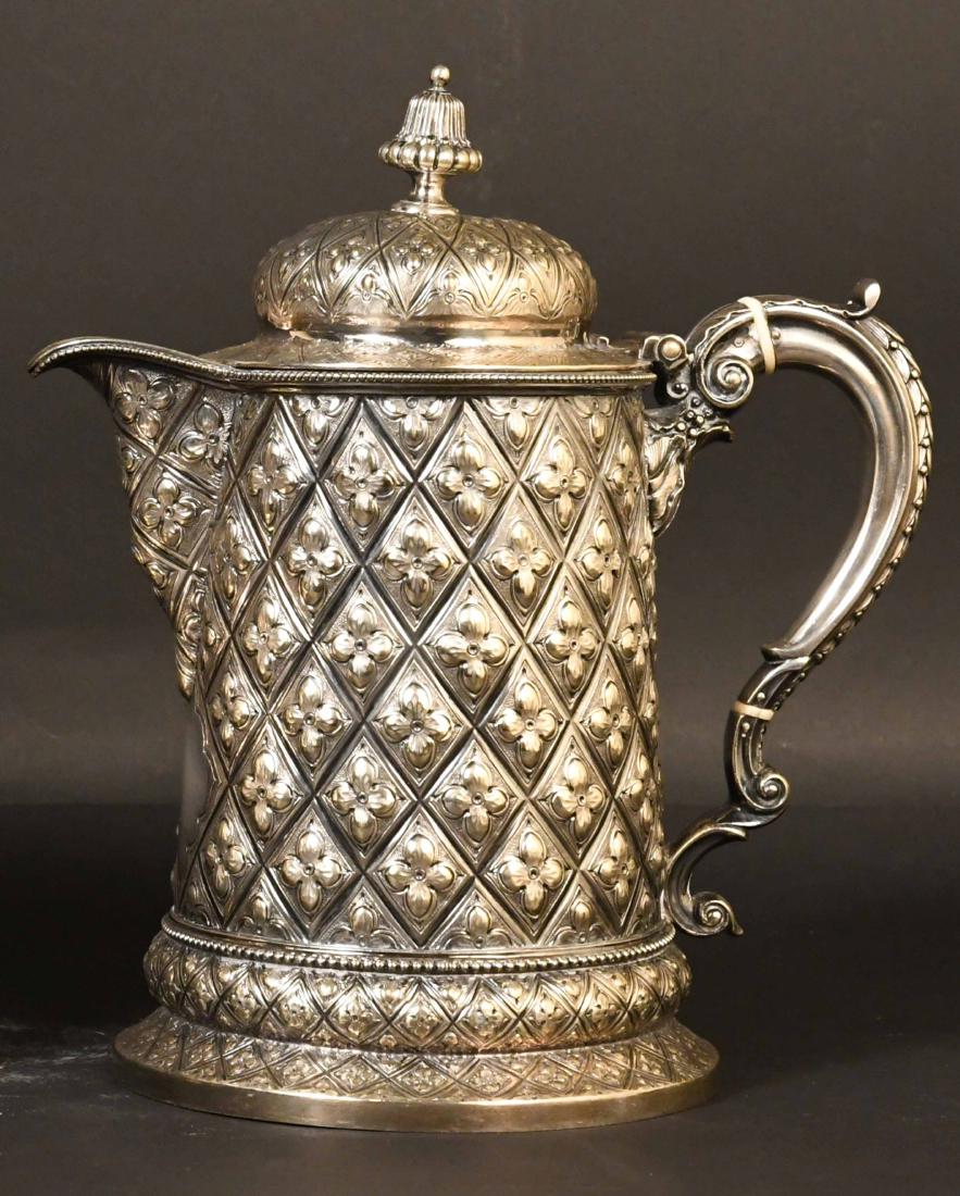 Ornately Chased Silver Plated Tankard: Lidded, all-over cross hatch motif, vermeil interior, fluted finial, handle stylized leaf decoration, beaded borders, raised on circular rim foot. 11"h to top of finial x 6-1/4"d.