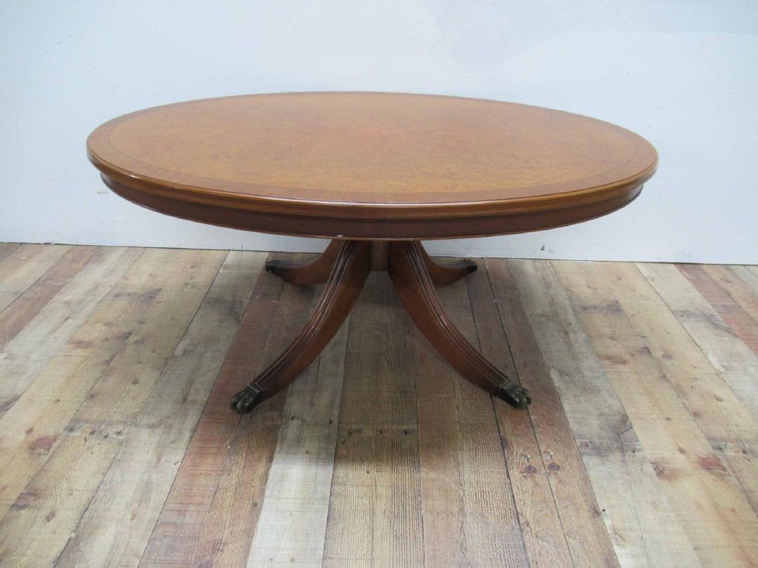 Duncan Phyfe Style Low Coffee Table: Mahogany in color with Burlwood center and oval shaped top. Resting on brass paw casters. 46 1/4 x L 30 1/2 W x 19 1/2 H