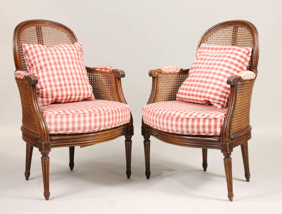 Pair of Louis XVI Style Walnut and Caned Bergeres: French, 19th/20th C. Losses to cane. 34-3/4"h x 23"w, over arms.