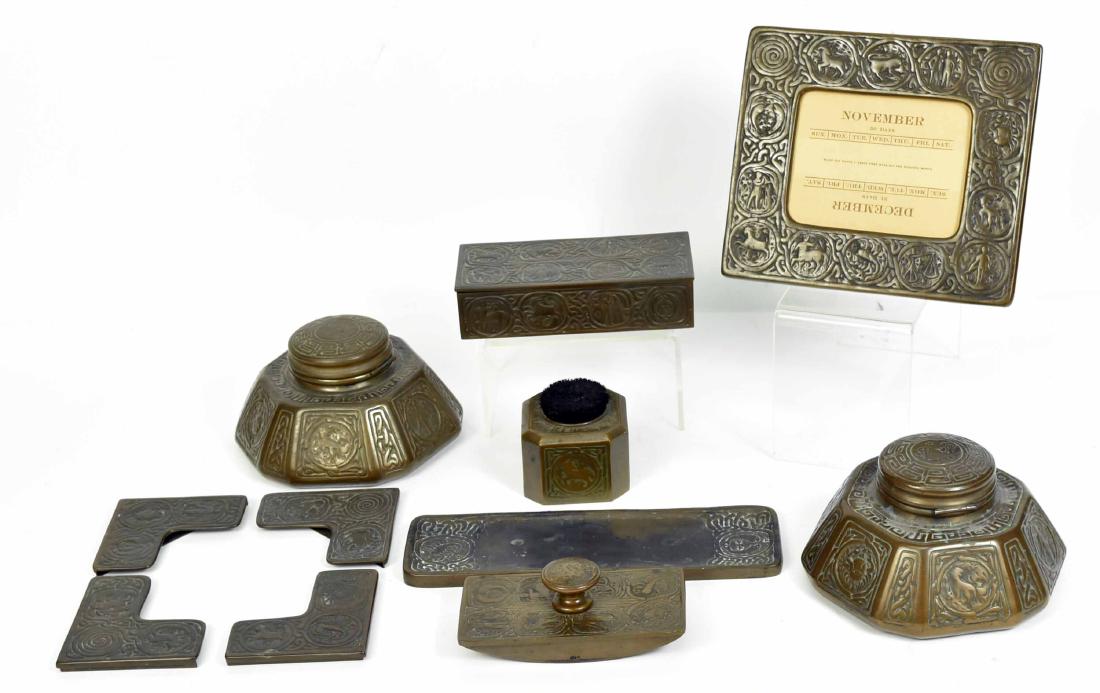 Tiffany Studios Zodiac Pattern Bronze Desk Set: C. 1910, stamped Tiffany Studios/New York, various numbered, comprising a perpetual calendar, 7-1/4"h x 8"w, two inkwells, each 3-1/2"h, roller blotter, pen wipe, pen tray, 9-3/4"l x 3-1/4"w, rectangu
