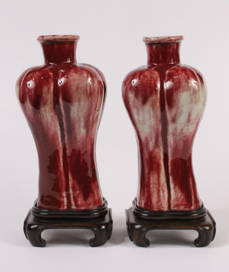 Pair of Chinese Sang De Boeuf Lobed Vases: Each on a hand-carved fitted stand. Bases drilled, formerly mounted as lamps. 12"h