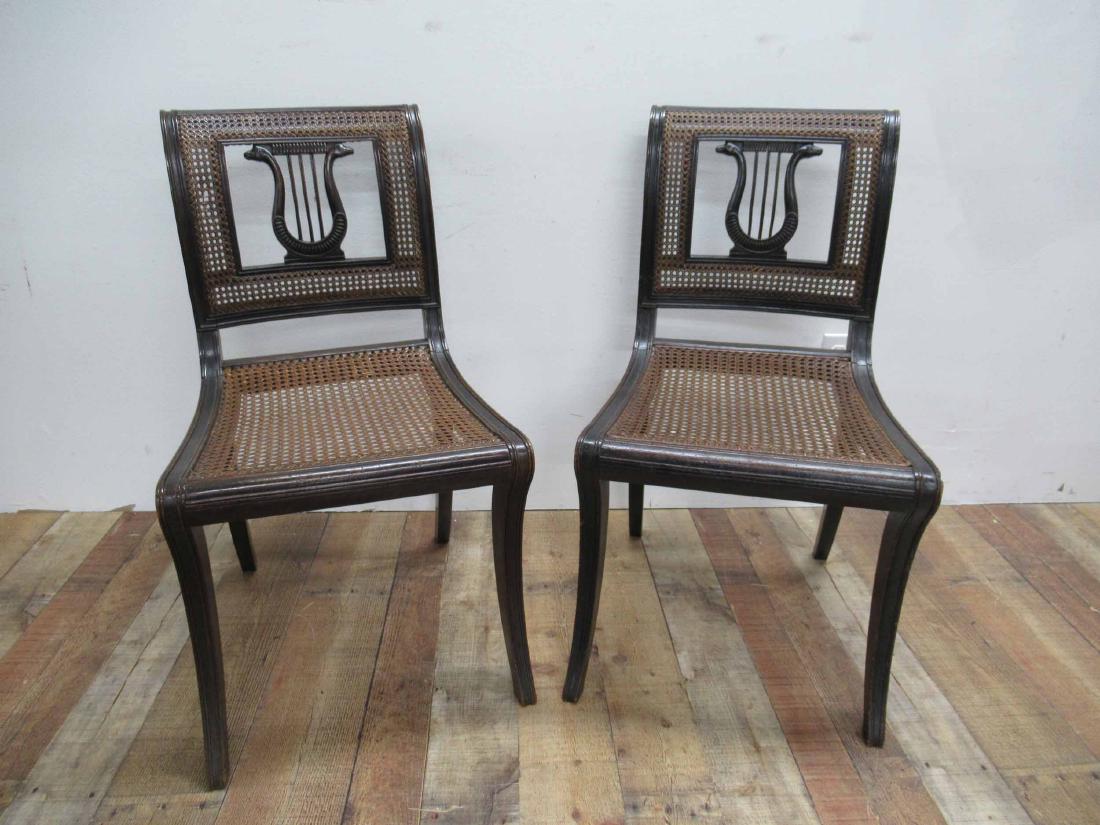 Pair of Regency Caned Side Chairs: Pair of Regency Caned Side Chairs having Lyre form backrest depicting serpents. Used condition, wear, worn. 33 1/2" tall x 18 1/2" wide x 19 1/2" deep.