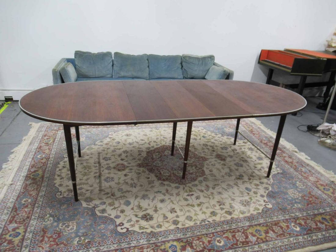 Paul McCobb Dining Table: Paul McCobb Dining Table Connoisseur collection having three leaves with metal boarders and stretcher base. Used condition, minor surface distress, some scratches, table will not closed fully. closed 