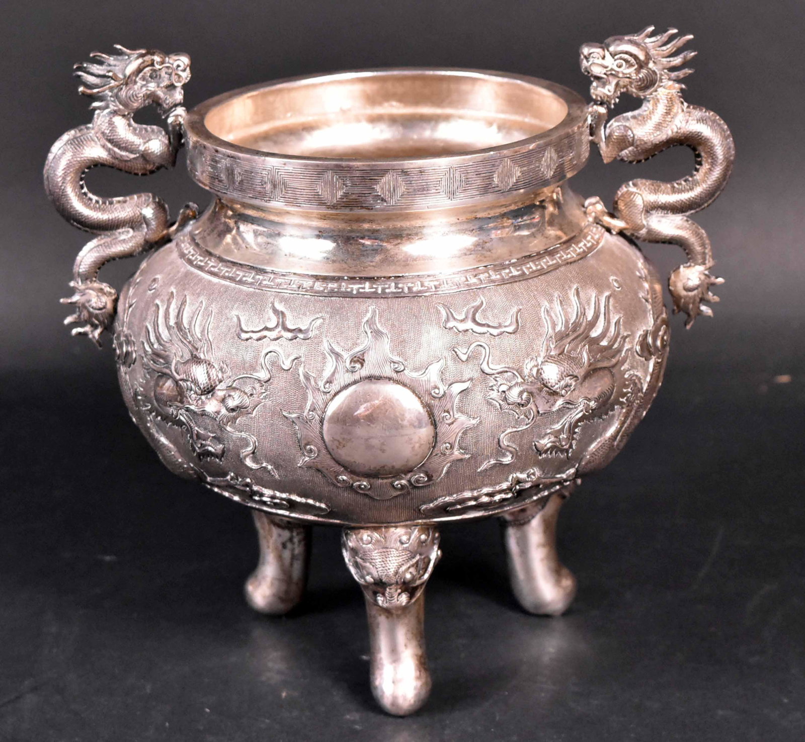Cambodian Silver Bowl: Second half 19th century, dragon scroll handles, flying dragon motif, raised on three mask handle topped cylindrical legs, 7-1/2"h x 8-1/2"d., weight approx. 25 T.O. Provenance: Property from the Coll