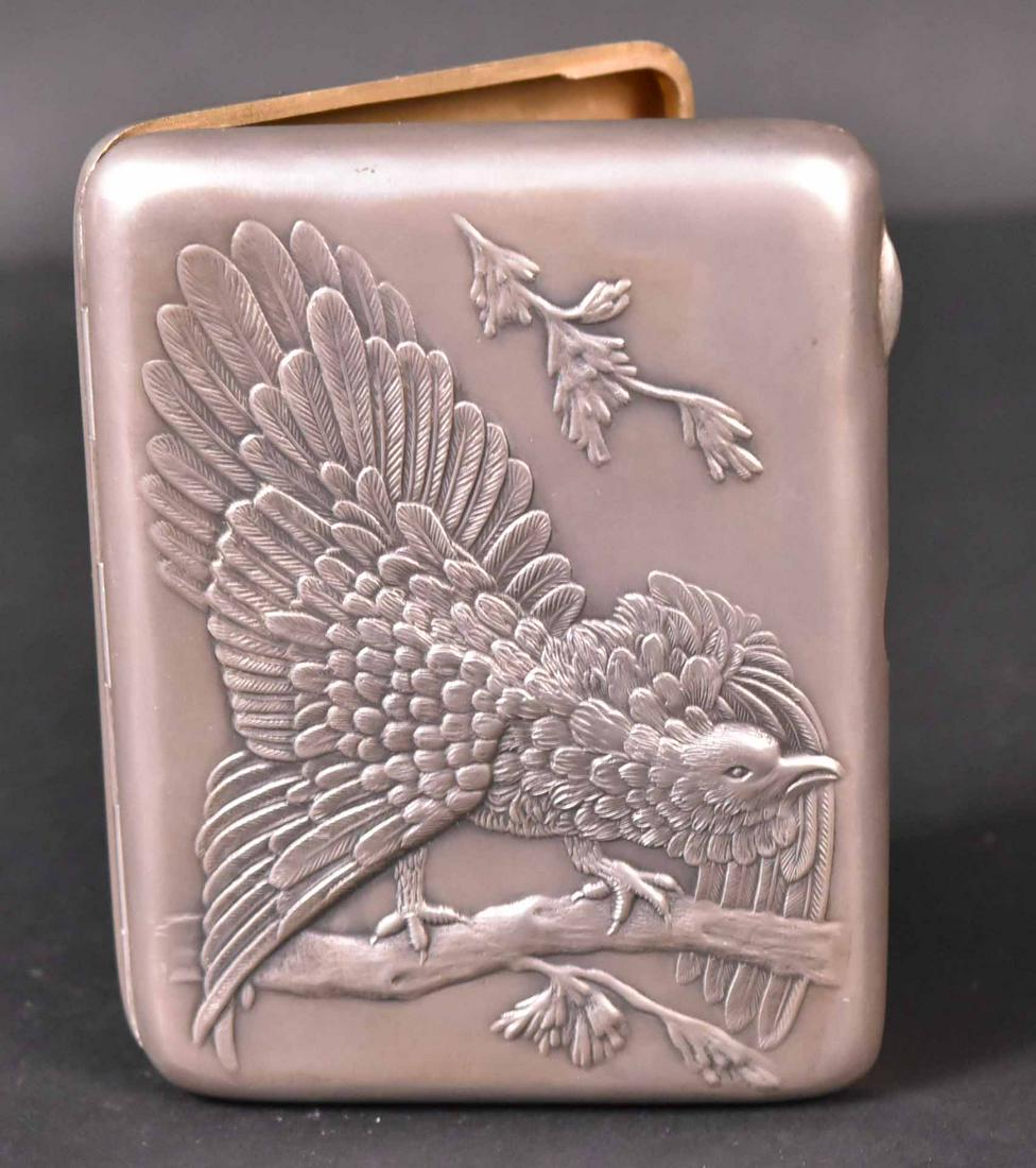 Eagle Chased Cover Russian Silver Cigar Case: Makers Mark AMIO3, gilt interior, cabochon red stone thumb piece, 4-1/4" x 3-1/4", weight approx. 5 T.O. Provenance: Property from the Collection of Myrna and Bernard Posner