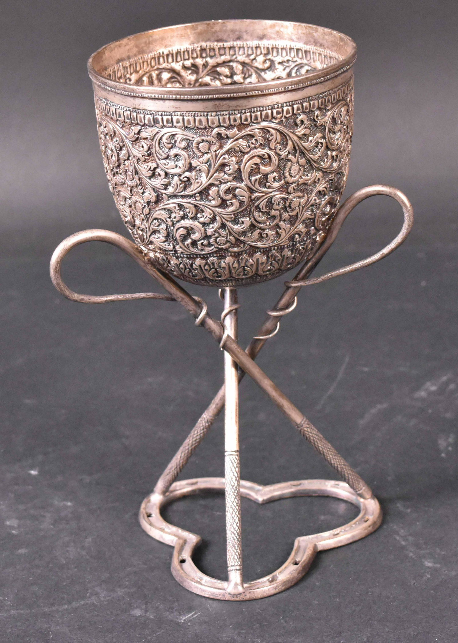 Indian Silver Standing Cup: C. 1900, chased with dense scrolling foliage, on tri-form base. 6-3/4"h Apx. 7 T.O Provenance: Property from the Collection of Myrna and Bernard Posner