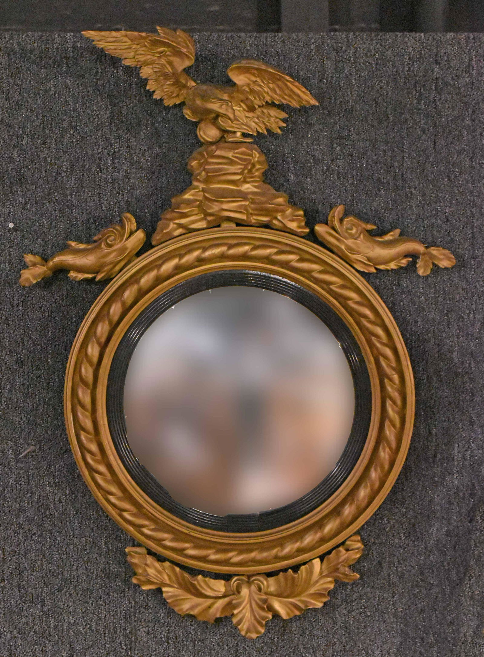Neoclassical Part-Ebonized Giltwood Convex Mirror: American or English, 19th/20th C., with eagle surmount flanked by dolphins. Apx. 38"h x 28"w Provenance: Property from an Ohio Estate.
