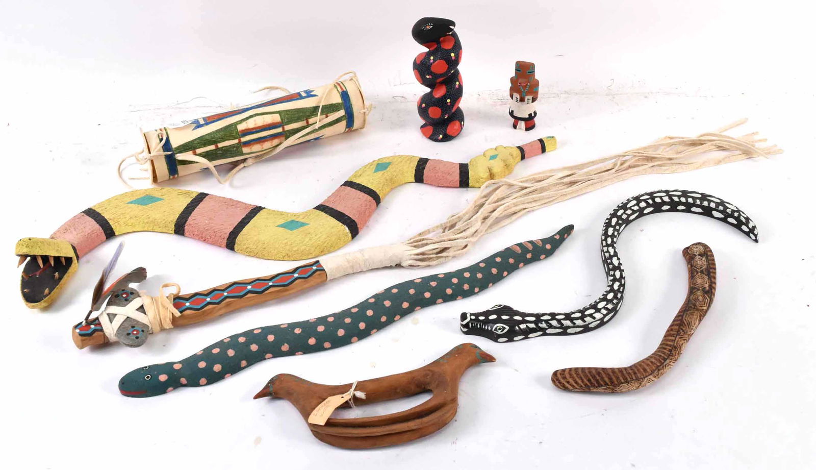 Group Southwest & Mexican Painted Wood Articles: Comprising five snake figures, one signed Davila and another signed Francis Melchorco. Together with a Native American tomahawk and drum, a Kachina figure and a carved wooden two head bird. Size longe