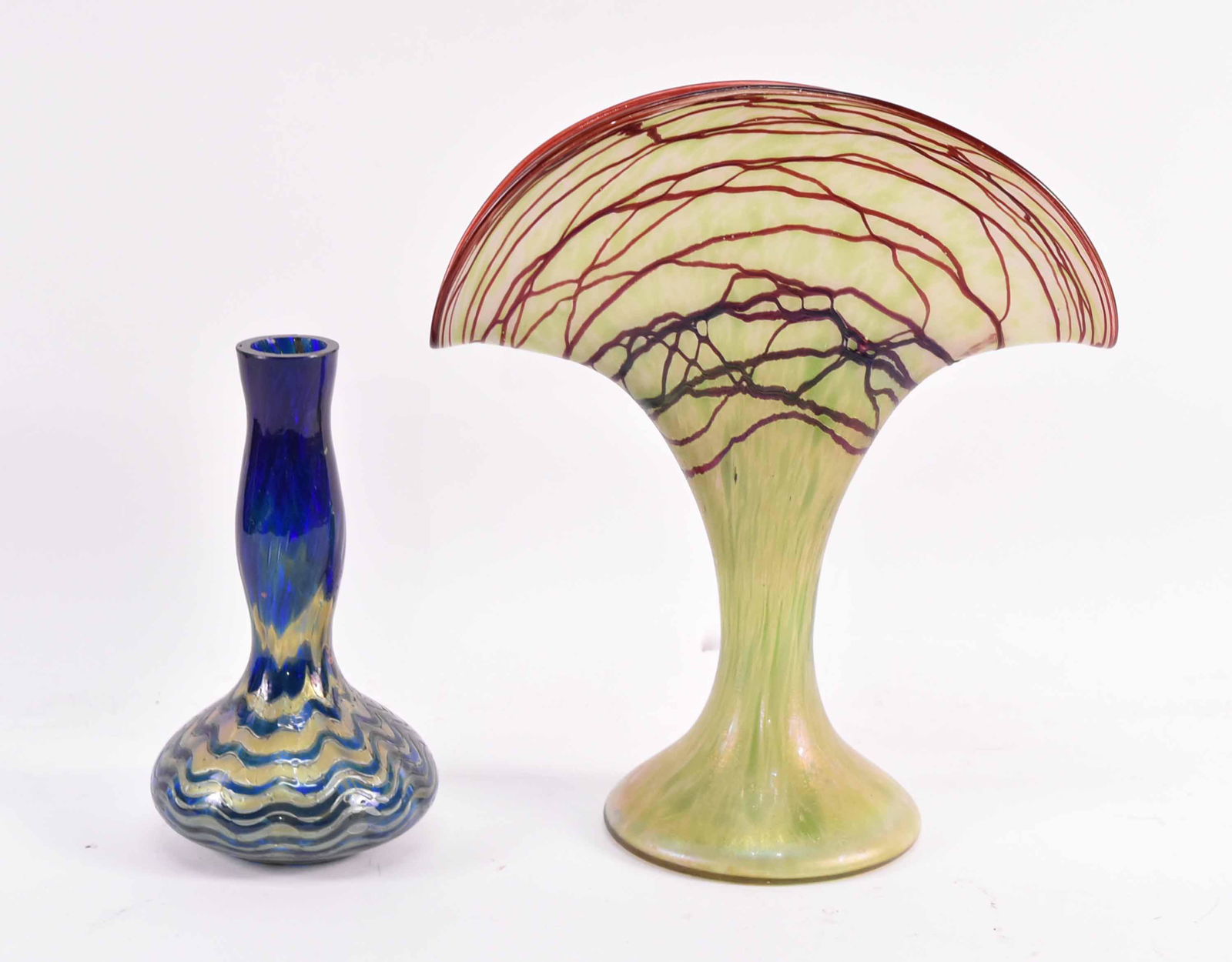 Two Austrian Loetz Glass Vases: On with green and purple glass in a fan shape, the other blue glass. 6-1/2"h and 9-3/4"h x 8-1/2"w Provenance: Property from an Ohio Estate.