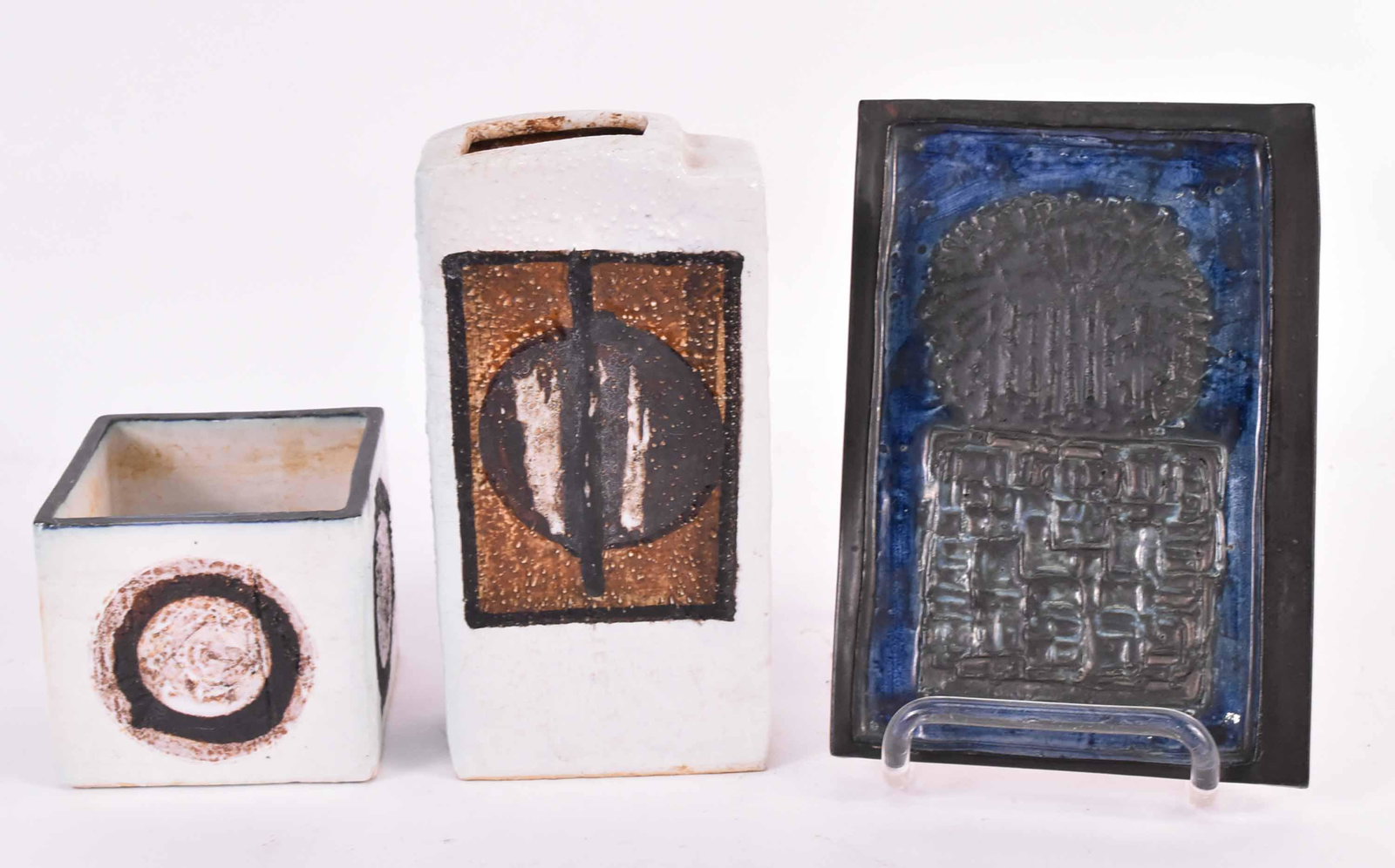 Troika St Ives English Pottery: English Mid Century modern abstract pottery. Comprising: a square slab vase, a tall chimney vase, and a dark blue plaque. 7"h