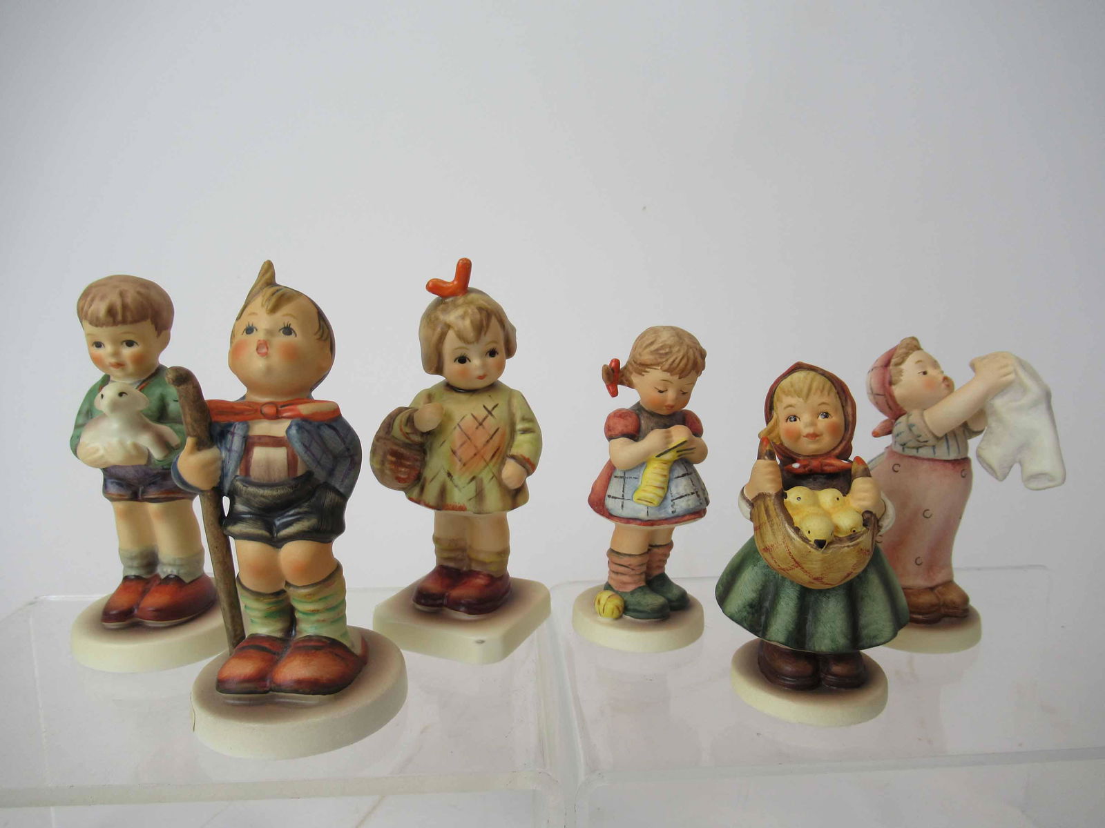 Six M. J. Hummel Goebel Figurines: Six M. J. Hummel Goebel Figurines including I Brought You A Gift, Little Hiker, Wash Day, I'll Protect Him with box, A Stitch In Time and Chicken Licken with box. Used condition. I'll Protect You size