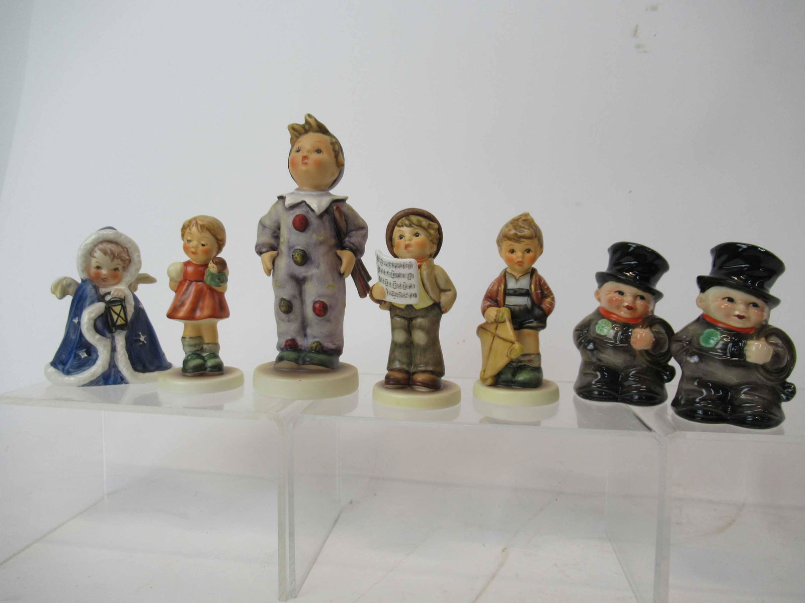 7 M. J. Hummel Goebel Figurines: 7 M. J. Hummel Goebel Figurines. Including Hitting the High Note, Angel with Lantern, Windy Wishes, Carnival, Puppet Princess and Chimney Sweep Salt Shakers. Used condition, base crazing, tallest 5 3/