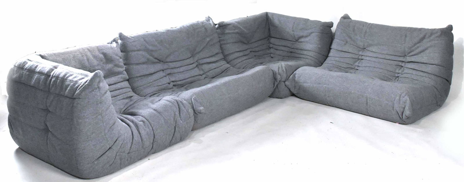 Michael Ducaroy "Togo" Sectional by Airborne: In four parts, grey upholstery, by Gustavo Olivieri Antiques. One button missing 28"h x 35"w x 14'l when straight