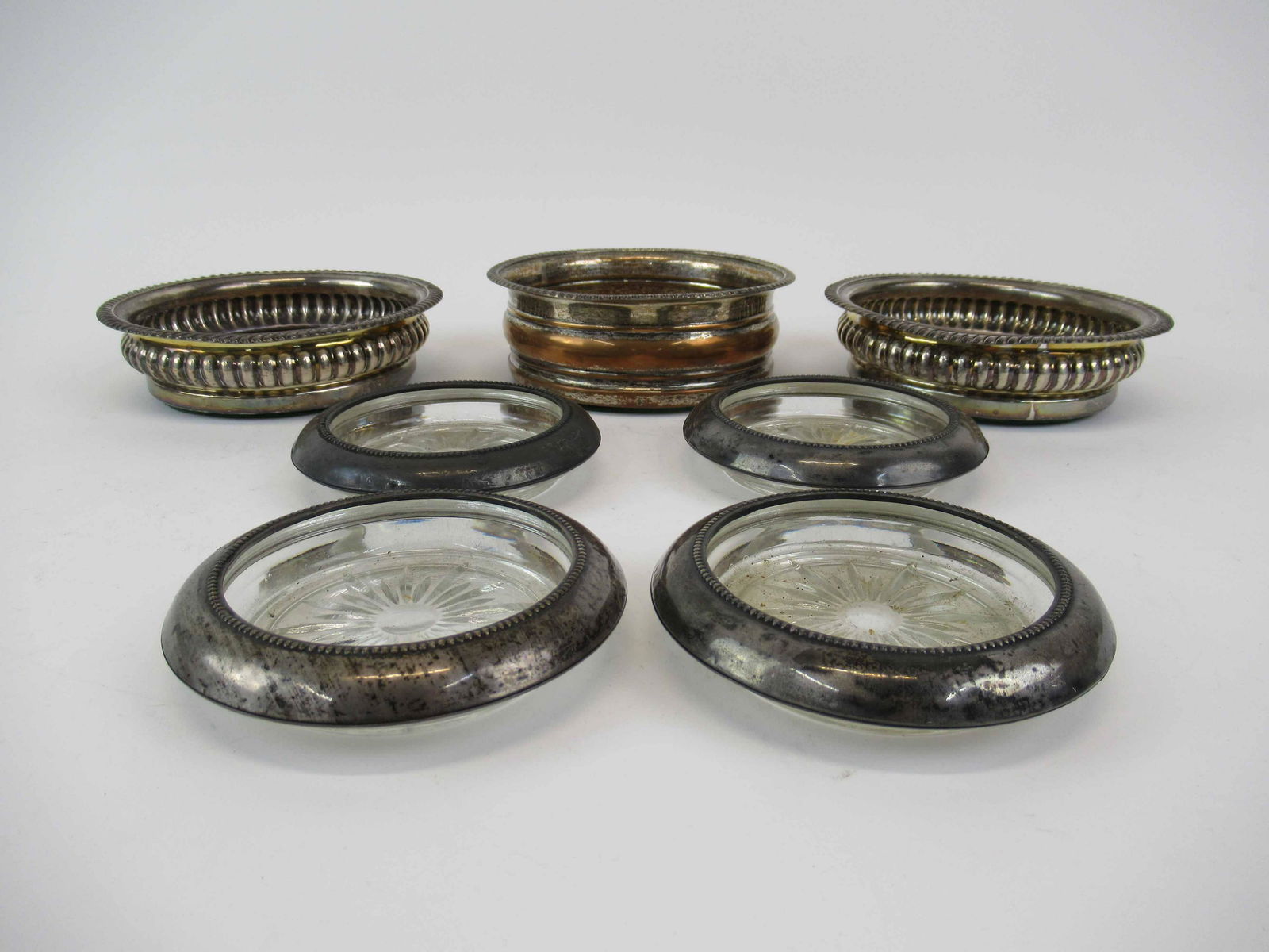 Pair of Silver Plated Wine Caddies: Together with another silver plated wine caddy, and four sterling silver mounted coasters. Used condition, wear, worn.