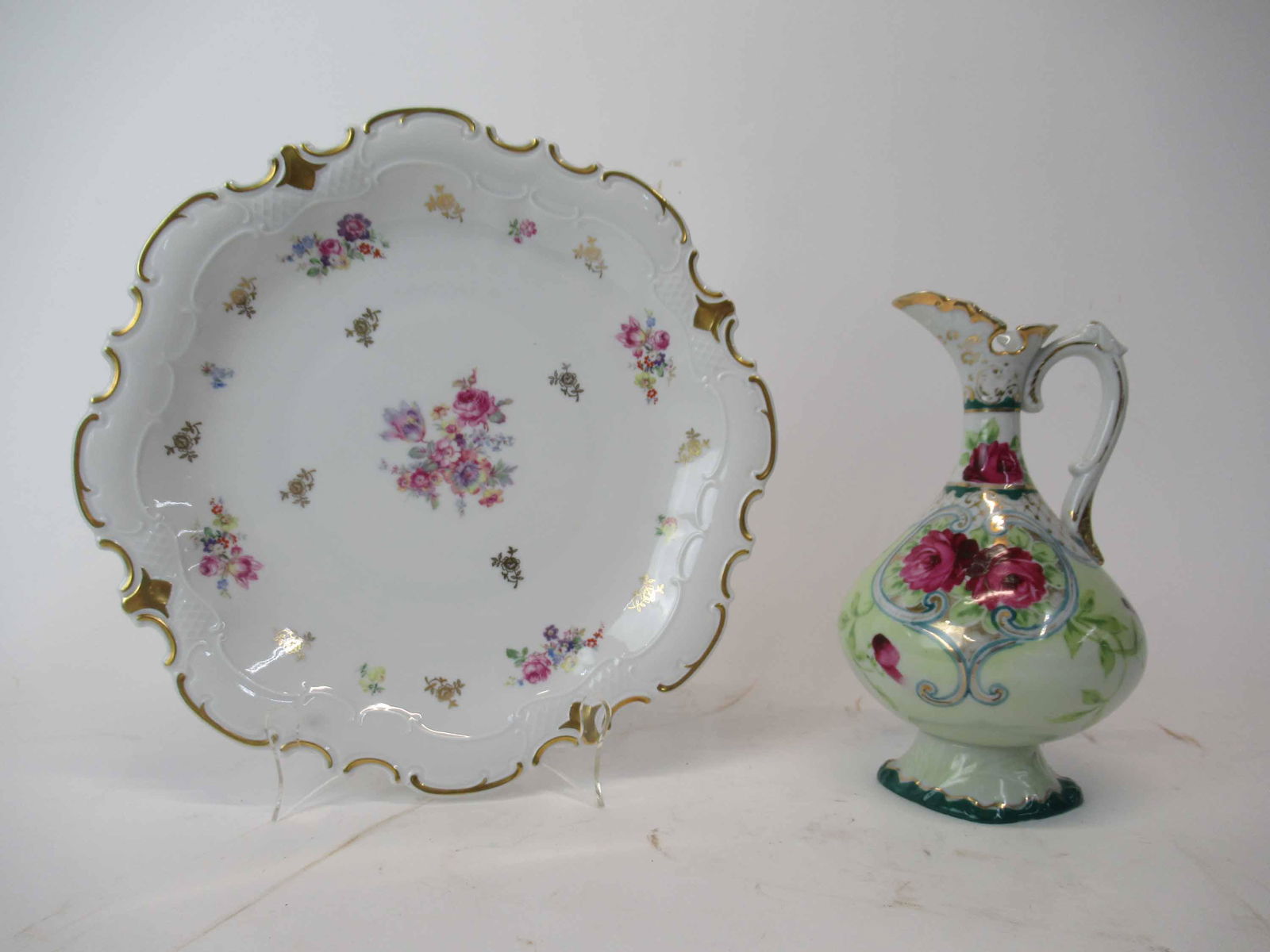 German Porcelain Center Plate: German Porcelain Center Plate having central floral decoration with gilt border. together with a floral decorated Ewer. Used condition. plate size 12 3/4" dia
