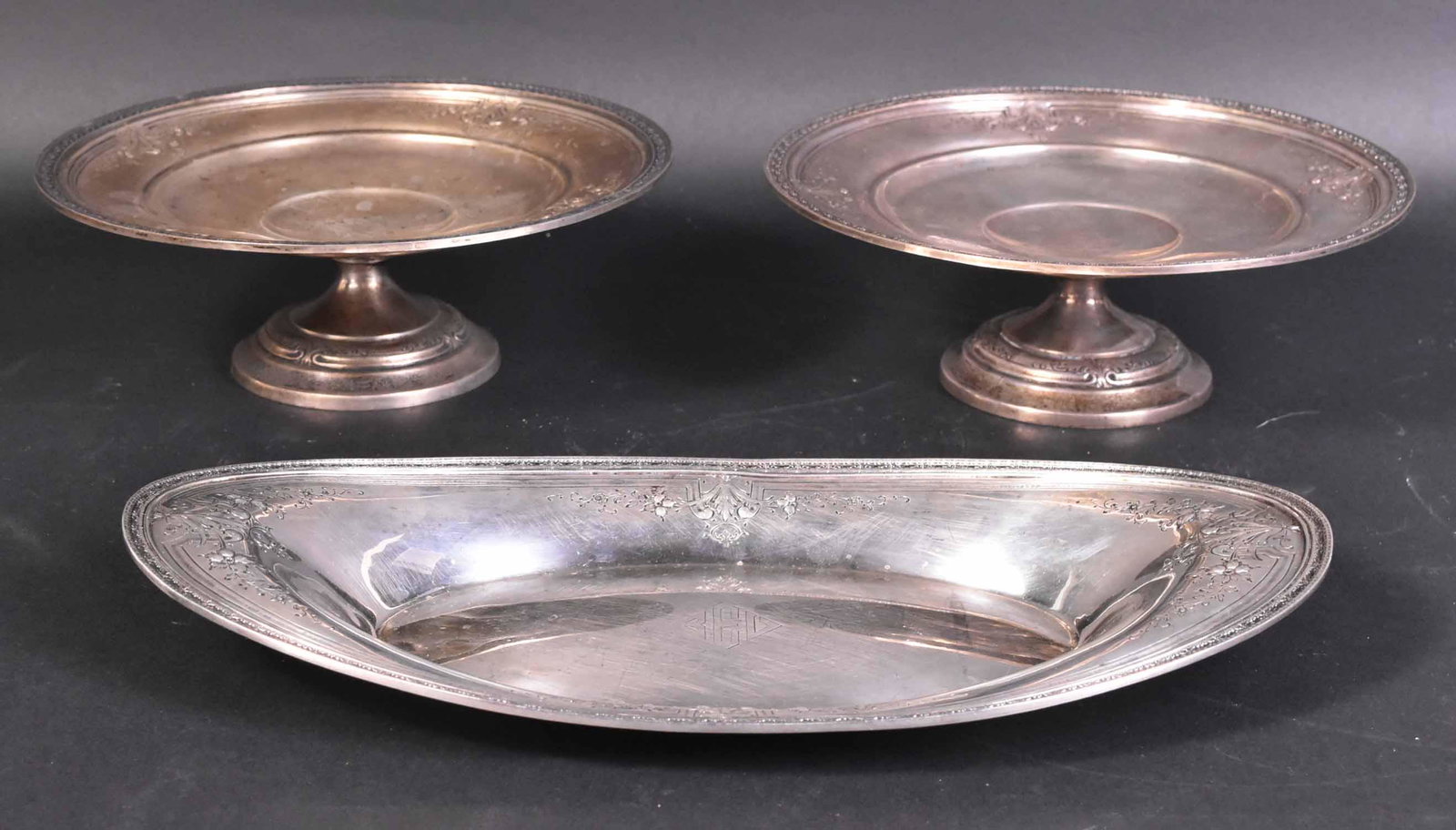 Redlich Sterling Silver Table Items: Comprising pair of footed compote, 3"h x 8.5"d, with matching centered monograms. Together with a similar pattern sterling silver oval bread tray, 13:l, Total weight approx. 40 T.O.