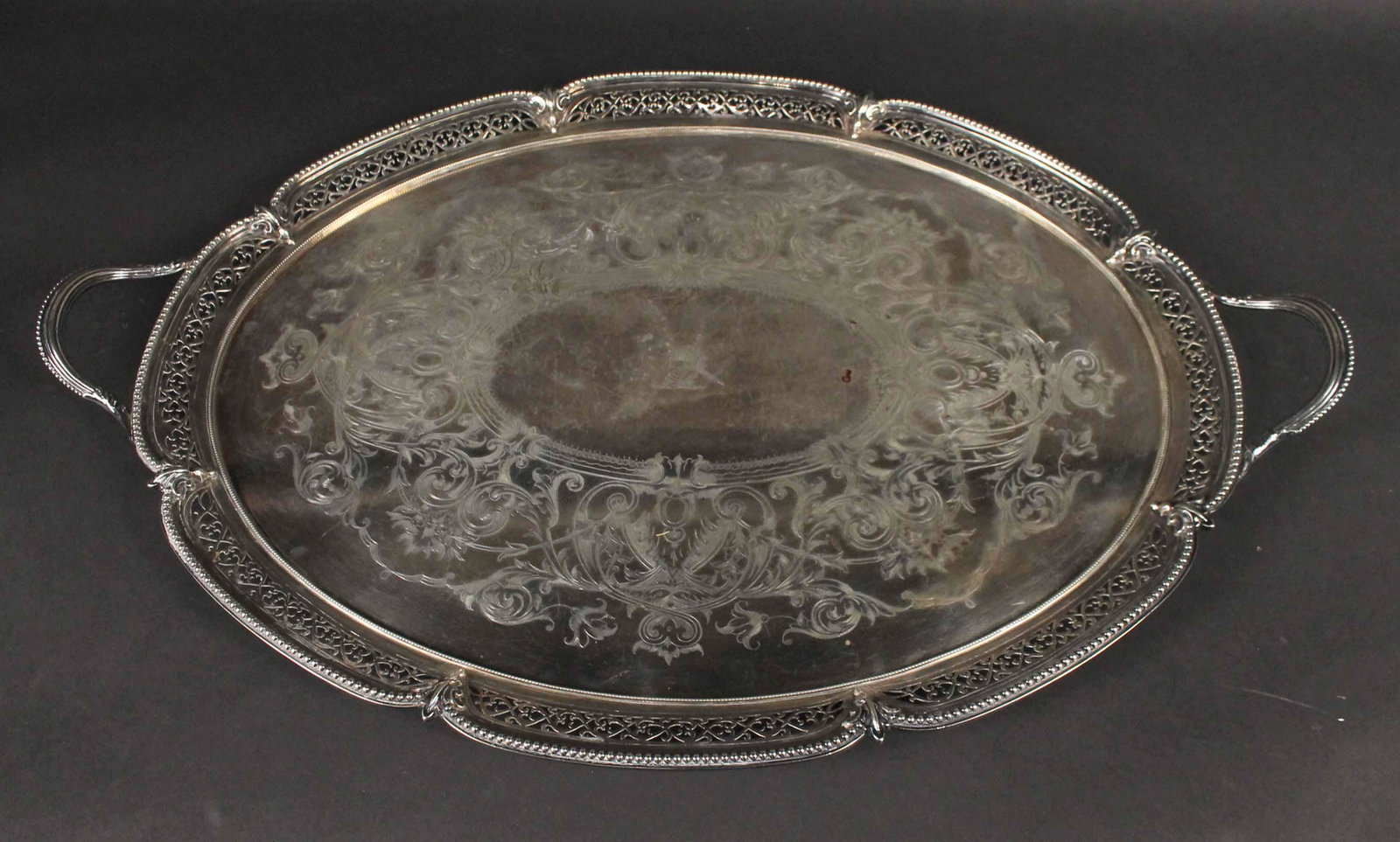 Silver Plated Double Handled Tea Tray: Early 20th Century, crested, engraved surface, pierced border, 29"l over handles. Provenance: Property from the Collection of Myrna and Bernard Posner