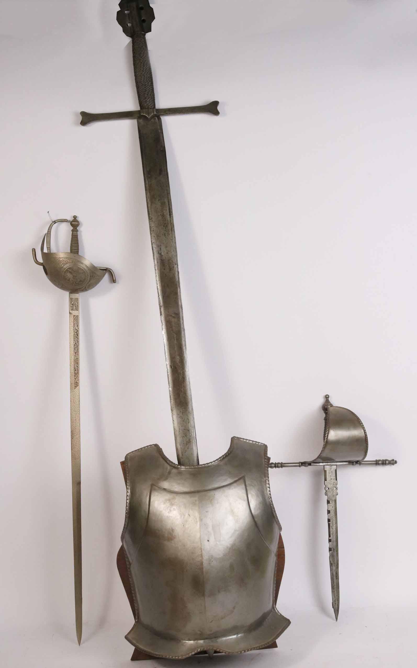 Reproduction Broadsword Mounted in a Breastplate: Together with two reproduction swords, a short sword and a cutlass. 3 pieces Broadsword: 4'3-1/2"l