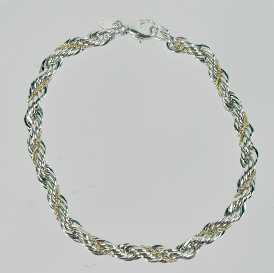 Tiffany & Co Sterling Silver 18K Gold Bracelet: Rope form bracelet with yellow gold chain intertwined, circular disk stamped Tiffany & Co 925 750, 7-1/4"l, weight approx. 8.80dwts.