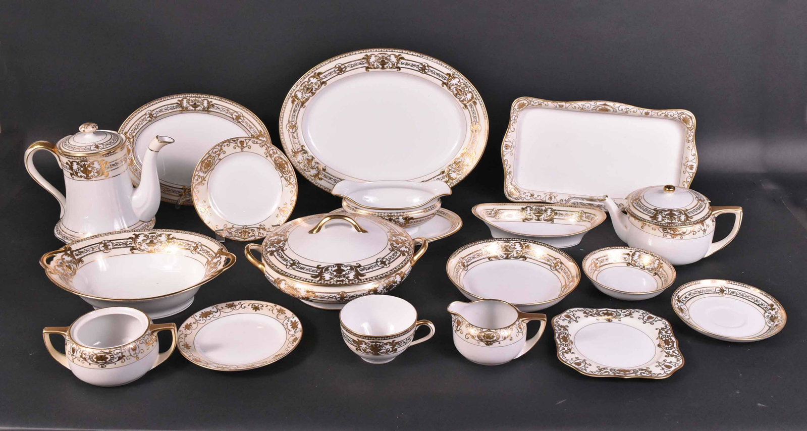 Set of Noritaki Parcel-Gilt Dinnerware: Comprising, three platters, a covered vegetable, two serving bowls, a gravy boat, a coffee pot, a teapot, a creamer and sugar, 12 dinner plates, 23 luncheon plates, 12 cream soups, 13 bread and butter