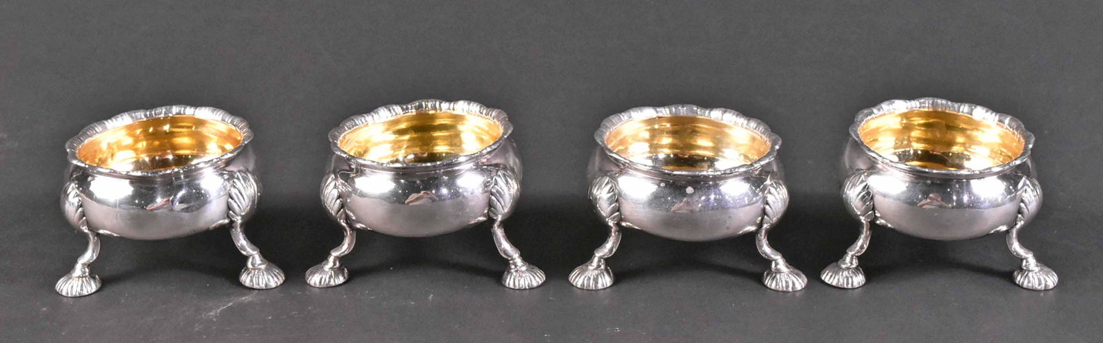 Set of Four English Georgian Silver Salt Cellars: Hallmarked R&D Hennell, London, 1790, vermeil interior, raised on shell feet, each 2"h x 2-3/4"d, total weight approx. 12 T.O. Provenance: Purchased S.Wyler, Inc, New York. Property from the Estate of