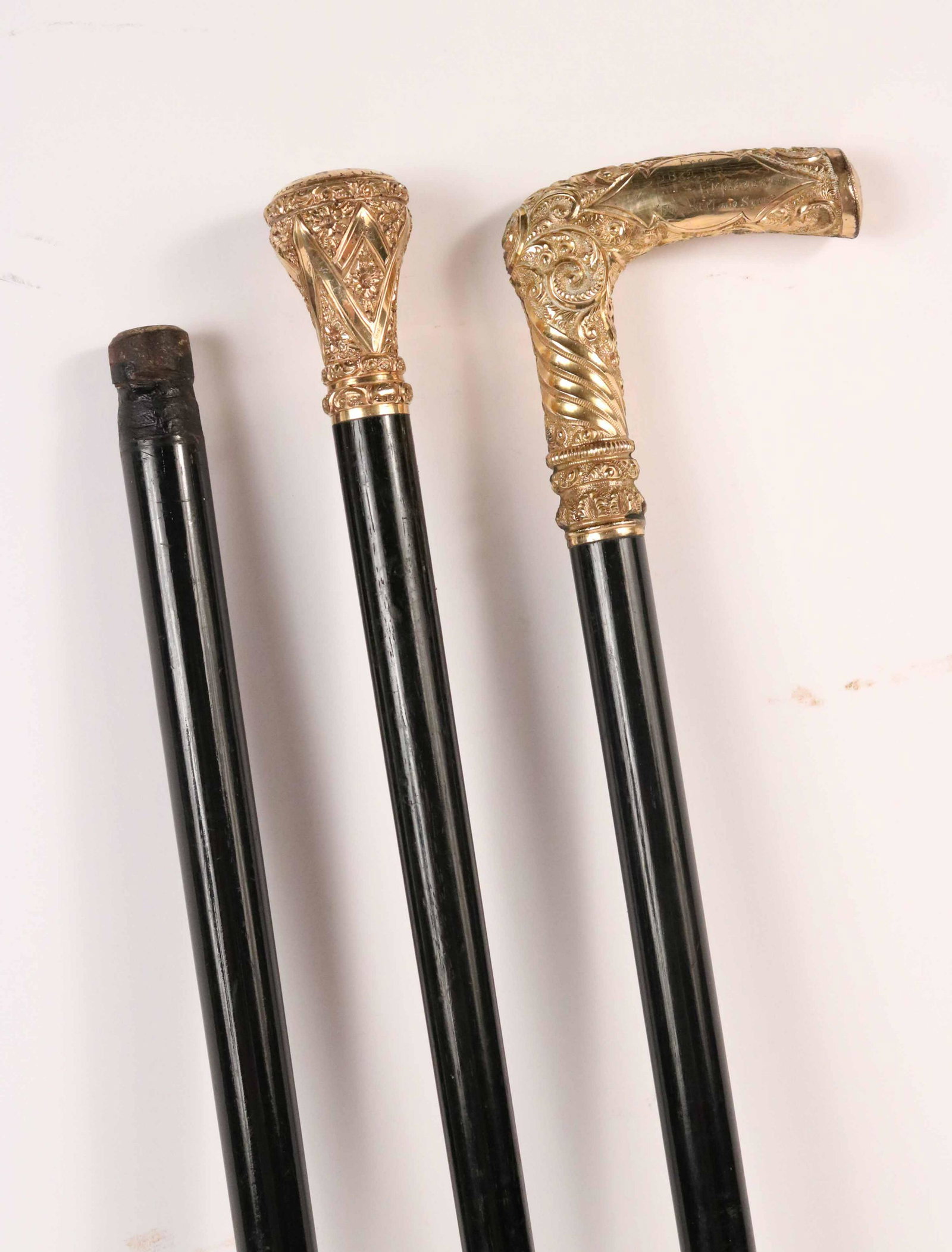A Vintage Rolled Gold Walking Stick and Cane: The first, engraved,"C.L. Pike 386 Harvard St Cambridge". The second a presentation cane." From C B & Q, R R Employees "For Auld Lang Syne," "Robert Bisset Sr. Creston IA" and a black cane without a t