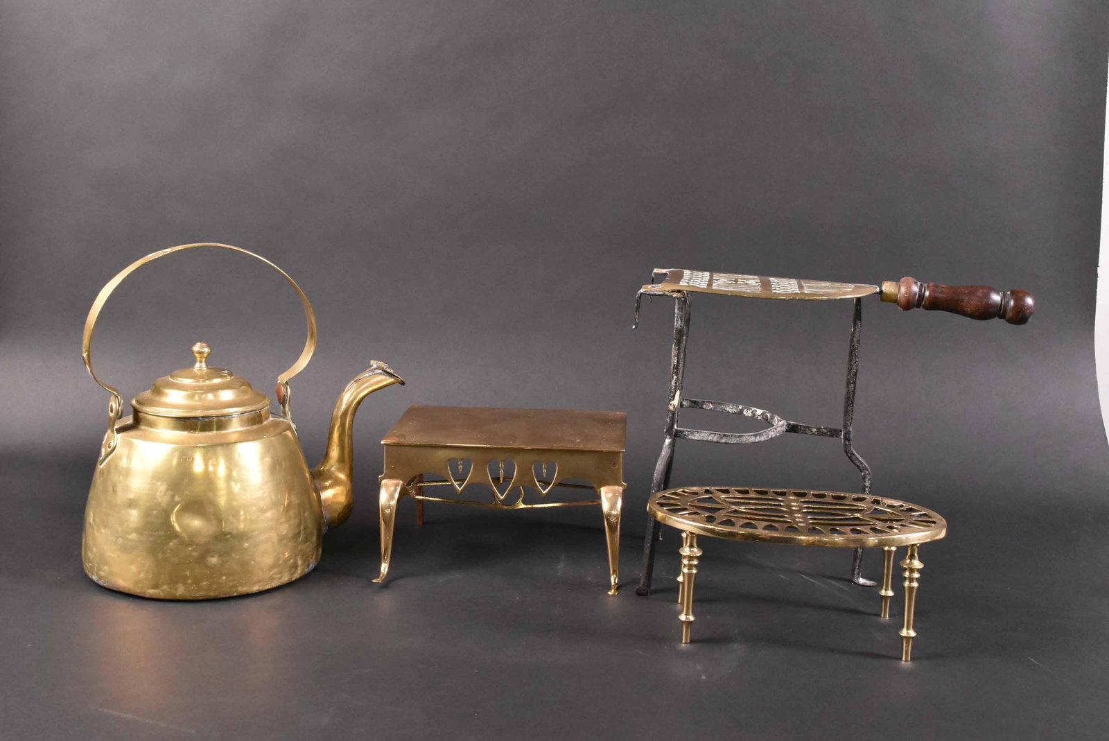 Brass Teapot Serpentine Spout & Associated Stand: Together with two miniature brass footman, 20th century. Size: Teapot 5"h Property from the Estate of Ralph & Roberta Carpenter.