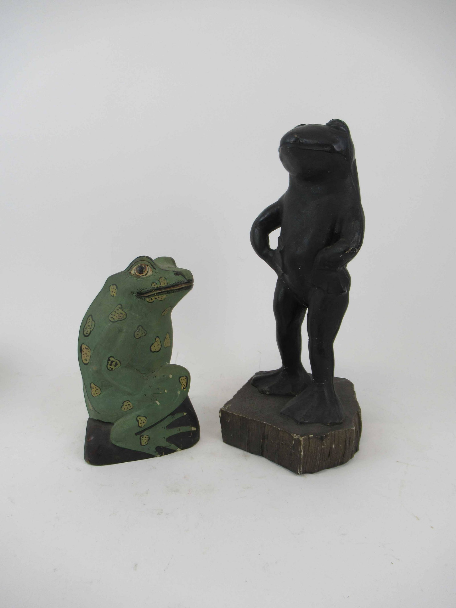 Composition Statue of a Frog: Composition Statue of a Frog. Together with a carved wooden painted statue of a frog. Used condition, black frog has repairs, wear, worn, paint loss. 16 1/4" tall