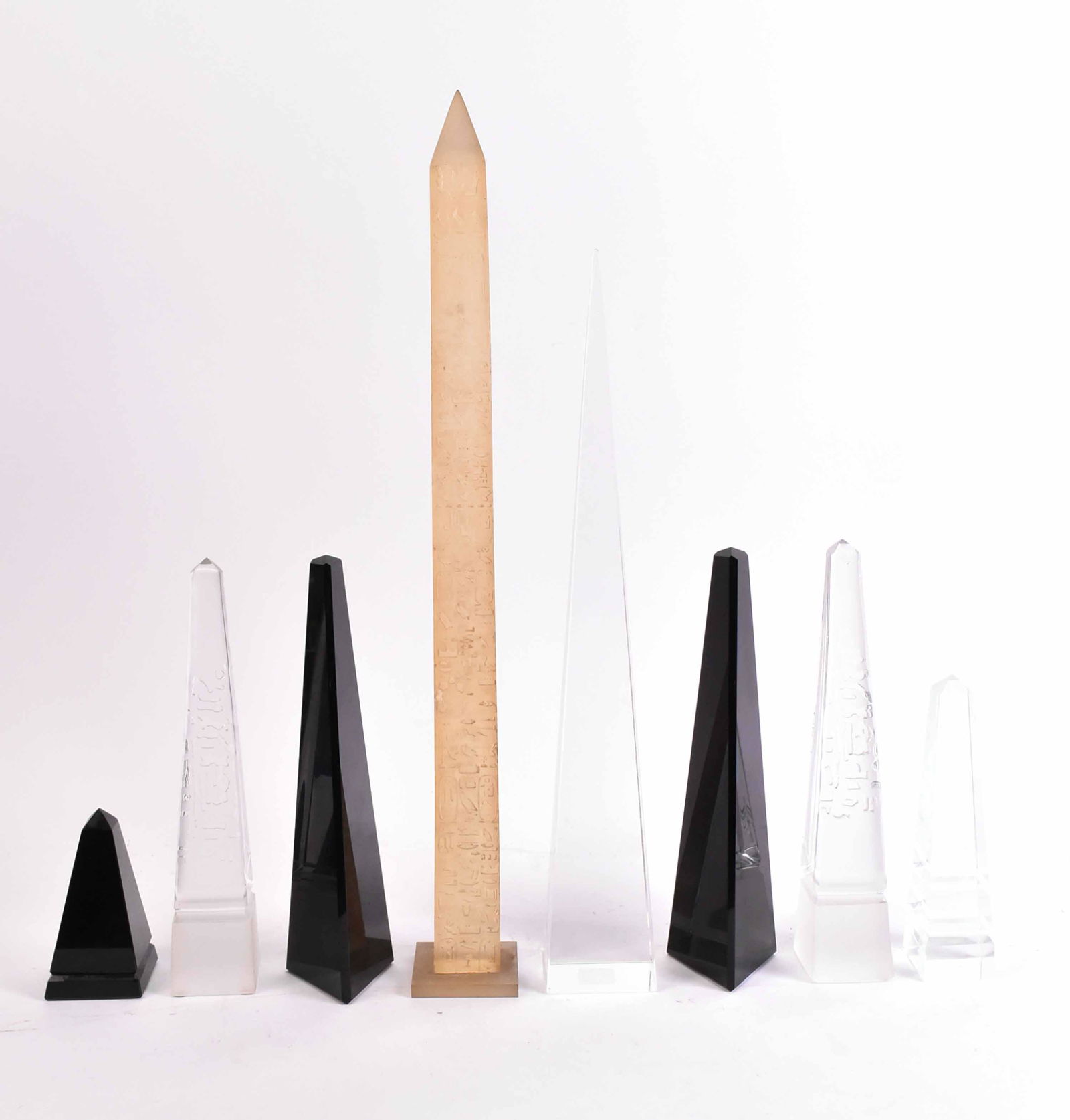 Eight Glass Obelisks: Comprising, a pair of colorless glass, two single colorless glass, a pair of black glass, and a pair of smaller black glass example. Together with a composition obelisk. 9 pieces From: 5"h to 24"h
