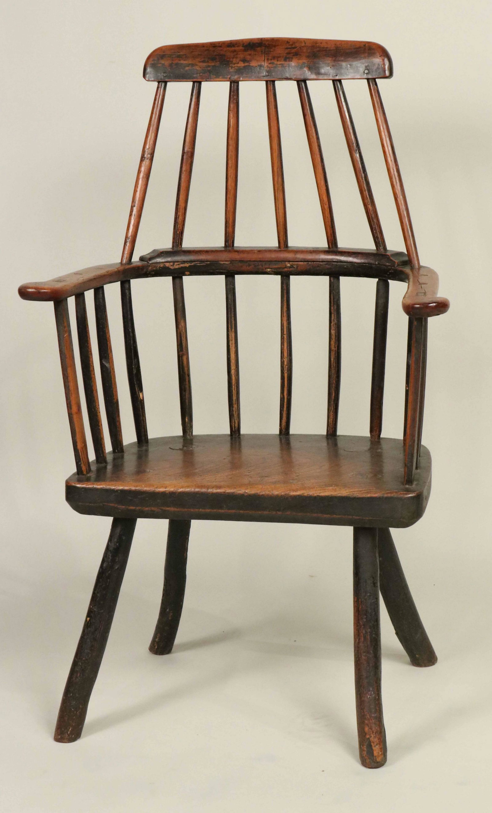 Primitive Oak Windsor Armchair: Welsh, c. 1800., with traces of original red-brown paint. Worm damage to one leg. 40"h Provenance: Property from the Estate of Judith Applegate, Princeton, NJ.
