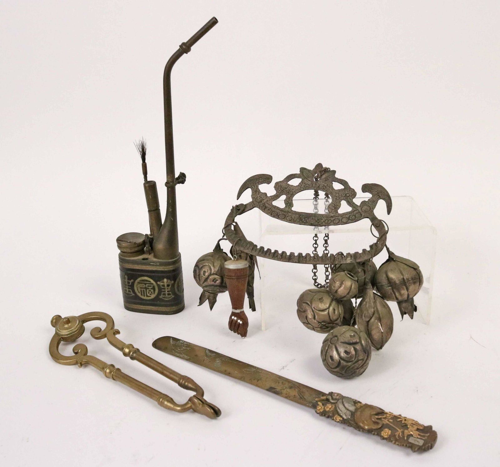 Assorted Ethnographic Mixed Metal Articles: Comprising a Chinese brass page turner and oil can, an African chimes and a pair of English brass ember tongs. Size: Tallest 13"h Provenance: Property from the Estate of Judith Applegate, Princeton, N