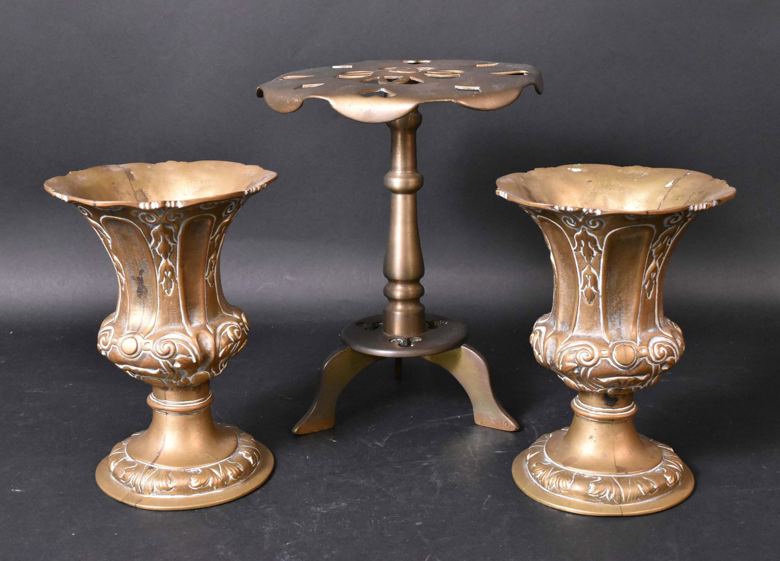Pair Cast Brass Urns: English, 18th Century. Together with a brass footed trivet. Size: Urns 8"h, trivet 10"h Provenance: Property from the Estate of Judith Applegate, Princeton, NJ.