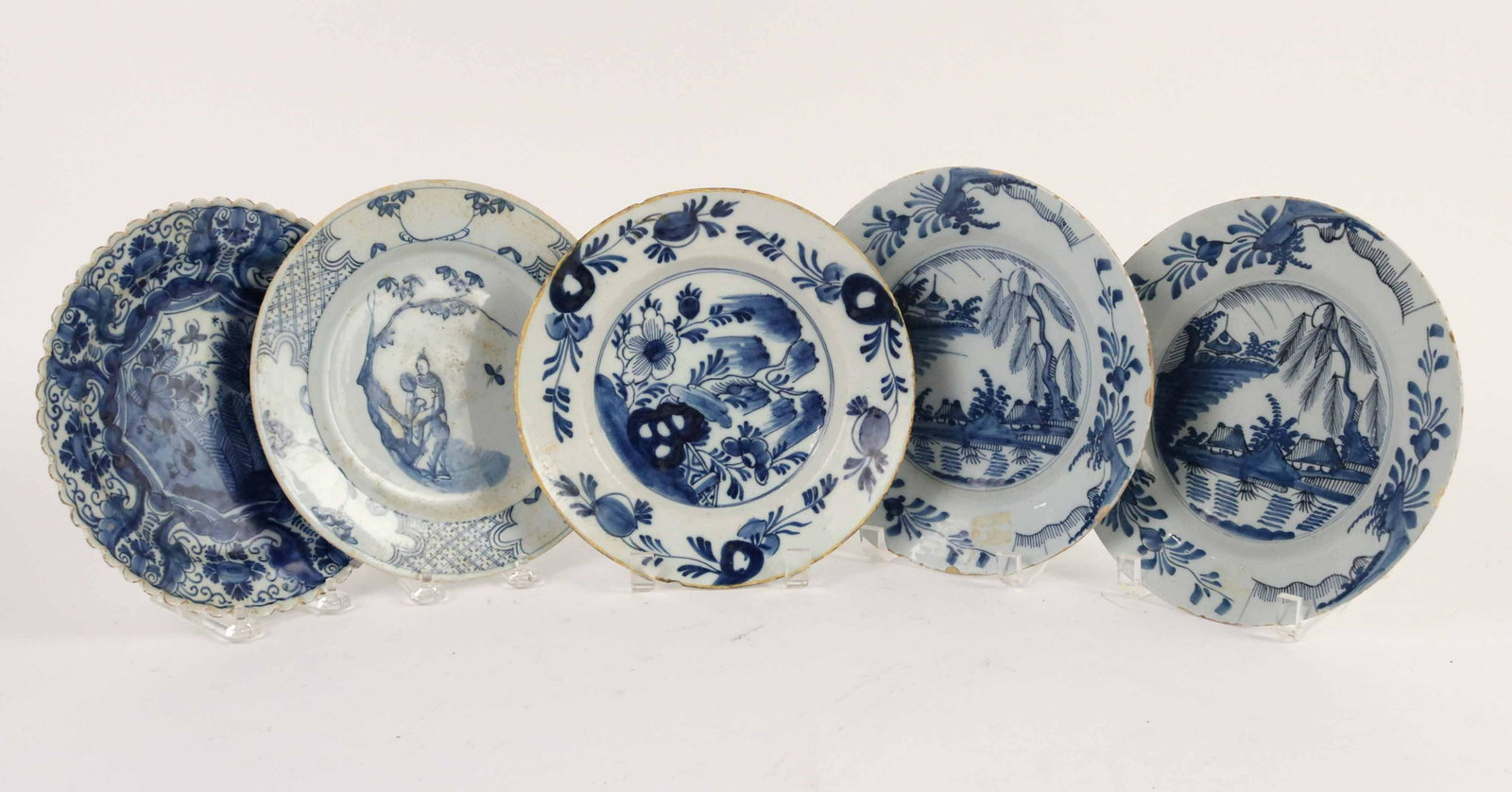 Five Blue and White Tin Glazed Earthenware Plates: English and Dutch, 18th Century. Comprising a Dutch Delft plate, an English Delft Chinoiserie plate, an English Delft plate with a Rockwork motif and a pair of Dutch Delft plates with a willow tree mo