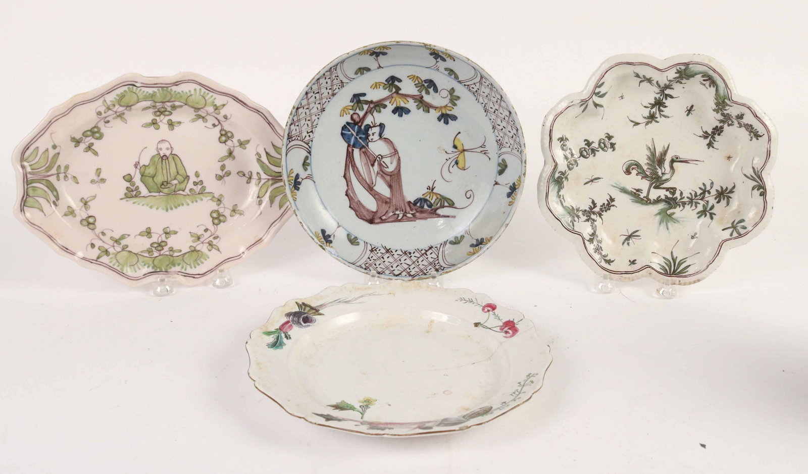 Four Tin Glazed Earthenware Plates: Comprising an 18th Century Bristol Delft shallow bowl, two 18th Century French Faience plates and a earthenware shaped plate with fish motif and old staple repairs. Size: 9 1/4"d Provenance: Property 