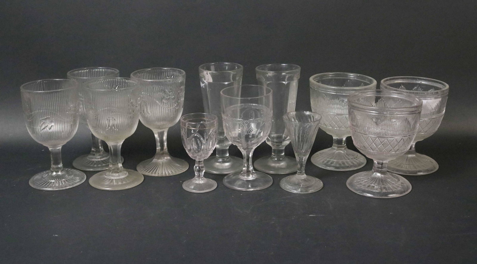 Thirteen Flint Glass "Ribbed Ivy" Goblet: Together with seven flint glass pointed diamond pattern buttermilk goblets, five assorted flint glass goblets, two cordial glasses and two parfait glasses. 29 pieces. Size: goblet 8"h Provenance: Prop