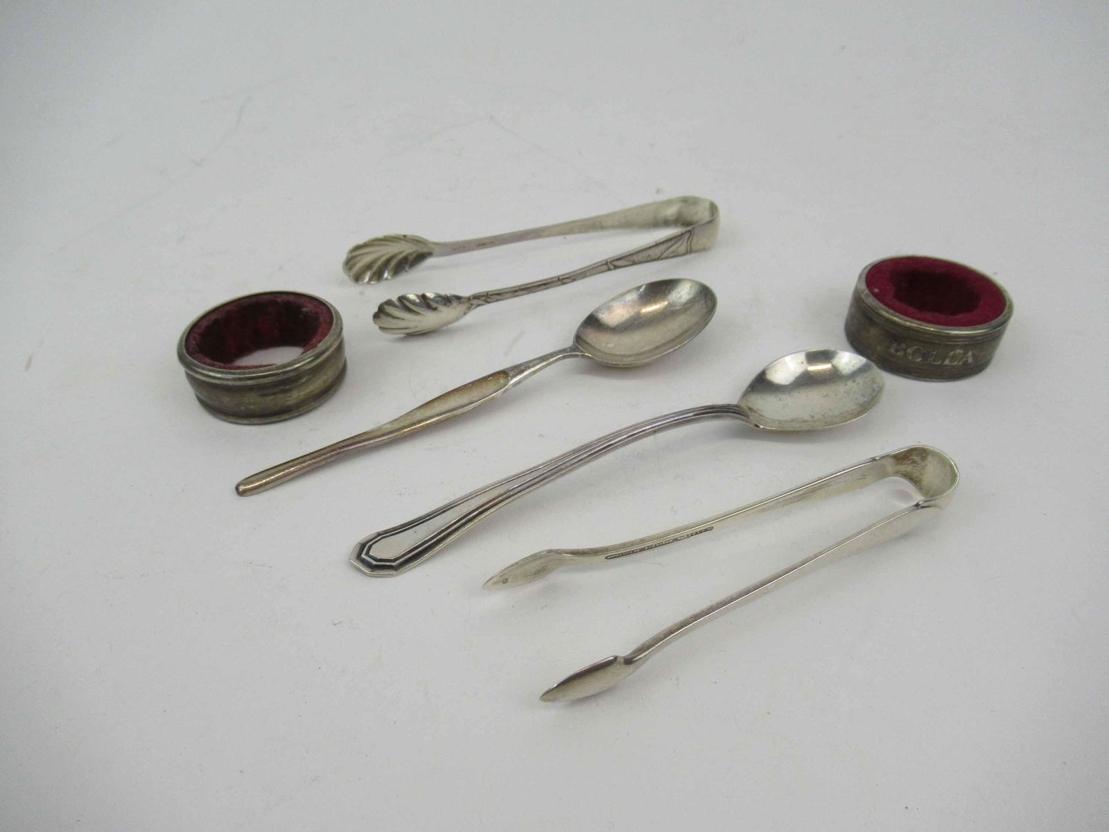 Tiffany Sterling Silver Sugar Tong: Tiffany Sterling Silver Sugar Tong. Together with a sterling silver tong. a sterling jam spoon, two silver wine collars, and a Christofle silver plated spoon. Used condition. Aprox 1.5 t.o. of Sterlin