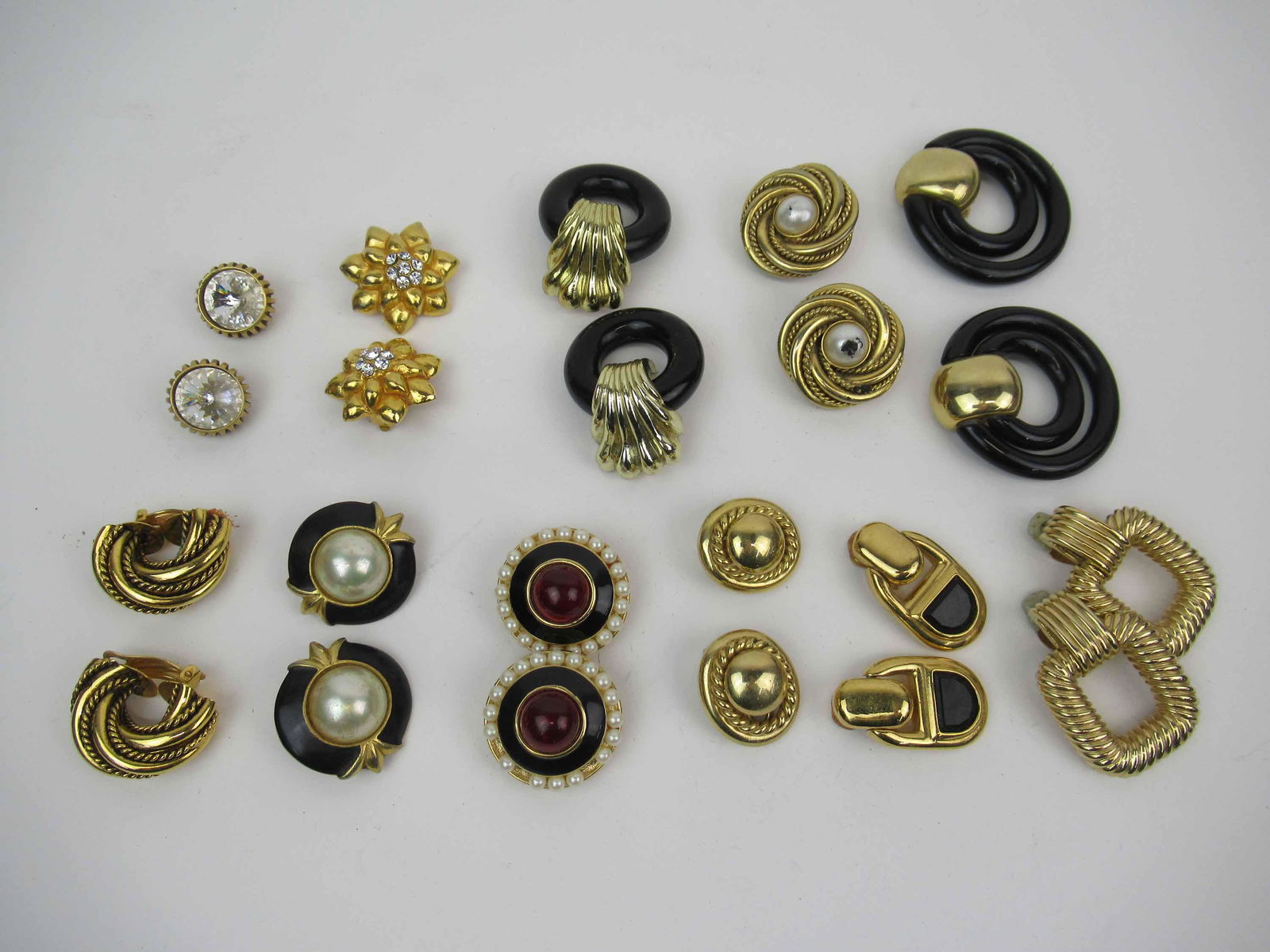 Eleven Pair Gold Tone Ear Clips: Eleven Pair Gold Tone Ear Clips, some with crystals, faux pearls, and onyx style. Lorenz, Carolee, and Ciner. Used condition, wear, worn. Provenance: Property from the Estate of Judith Applegate, Prin