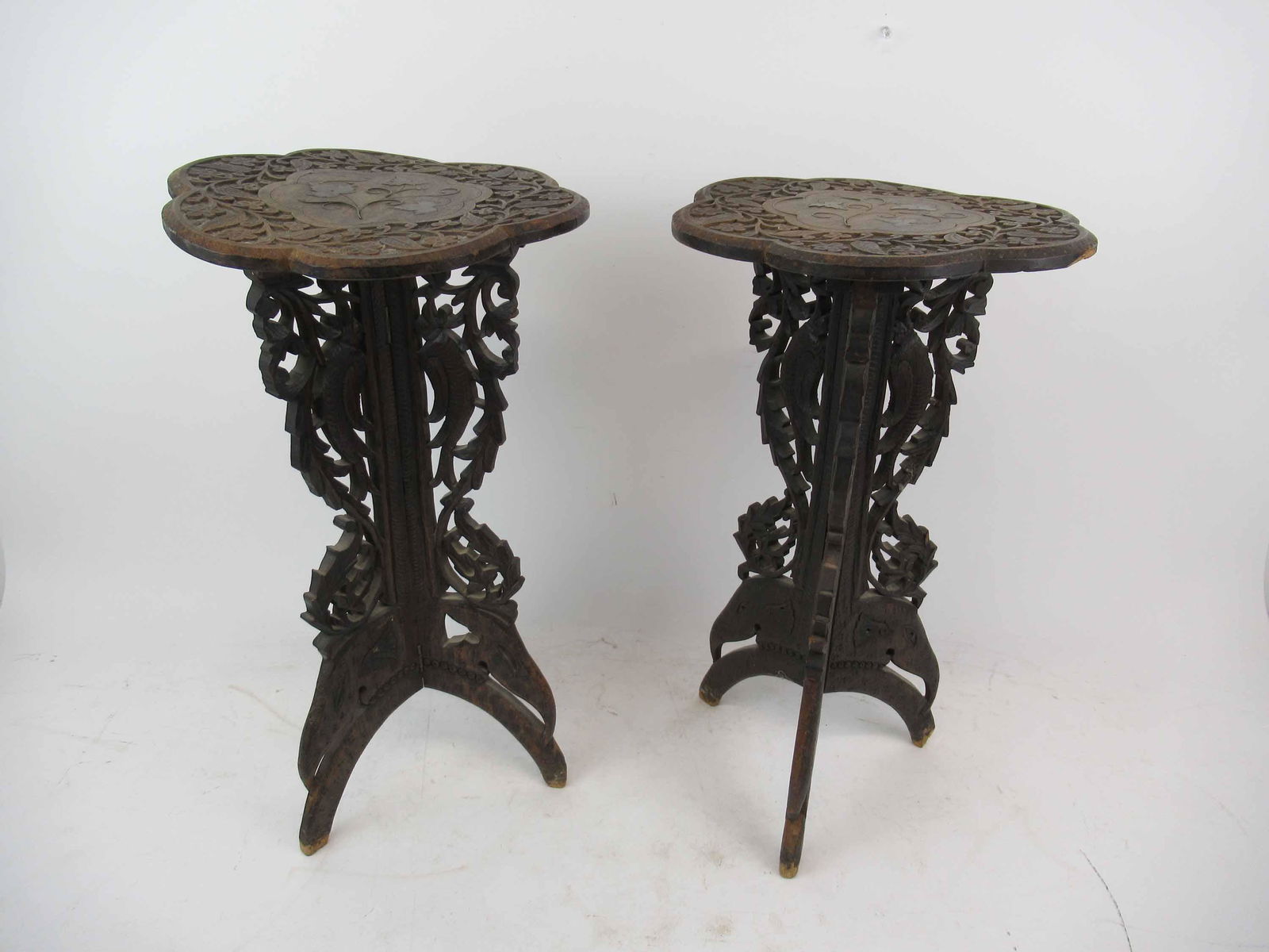 Pair of Hand Carved Hardwood Side Table: Pair of Hand Carved Hardwood Side Table, each having carved dish top depicting leaves and flowers. Resting a a tripod carved base of Elephant and birds. Used condition, wear, worn, warped, damaged, ma