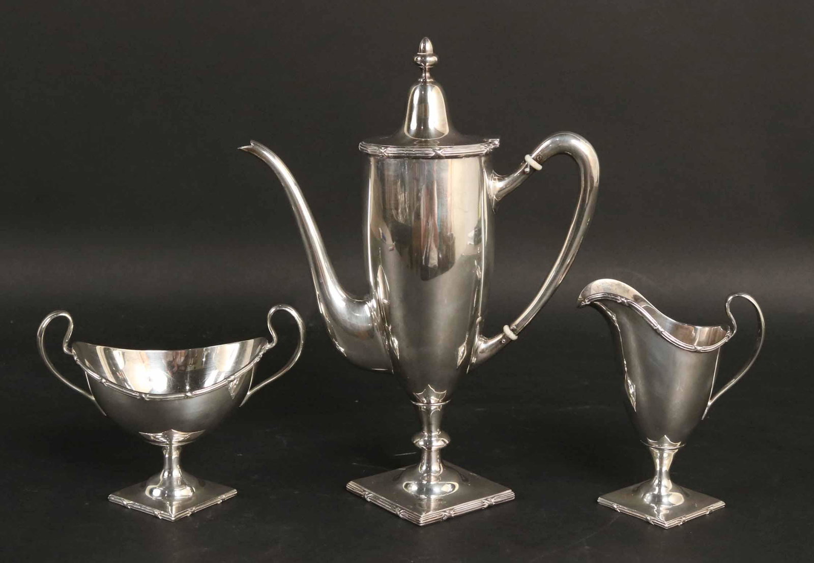 Mauser Sterling Silver Three Piece Coffee Service: 1767 Pattern, neoclassical vasiform on square form reeded base and borders, comprising coffee pot with urn form finial, 9-1/2"h, open sugar bowl and cream jug, total weight approx. 16 T.O.