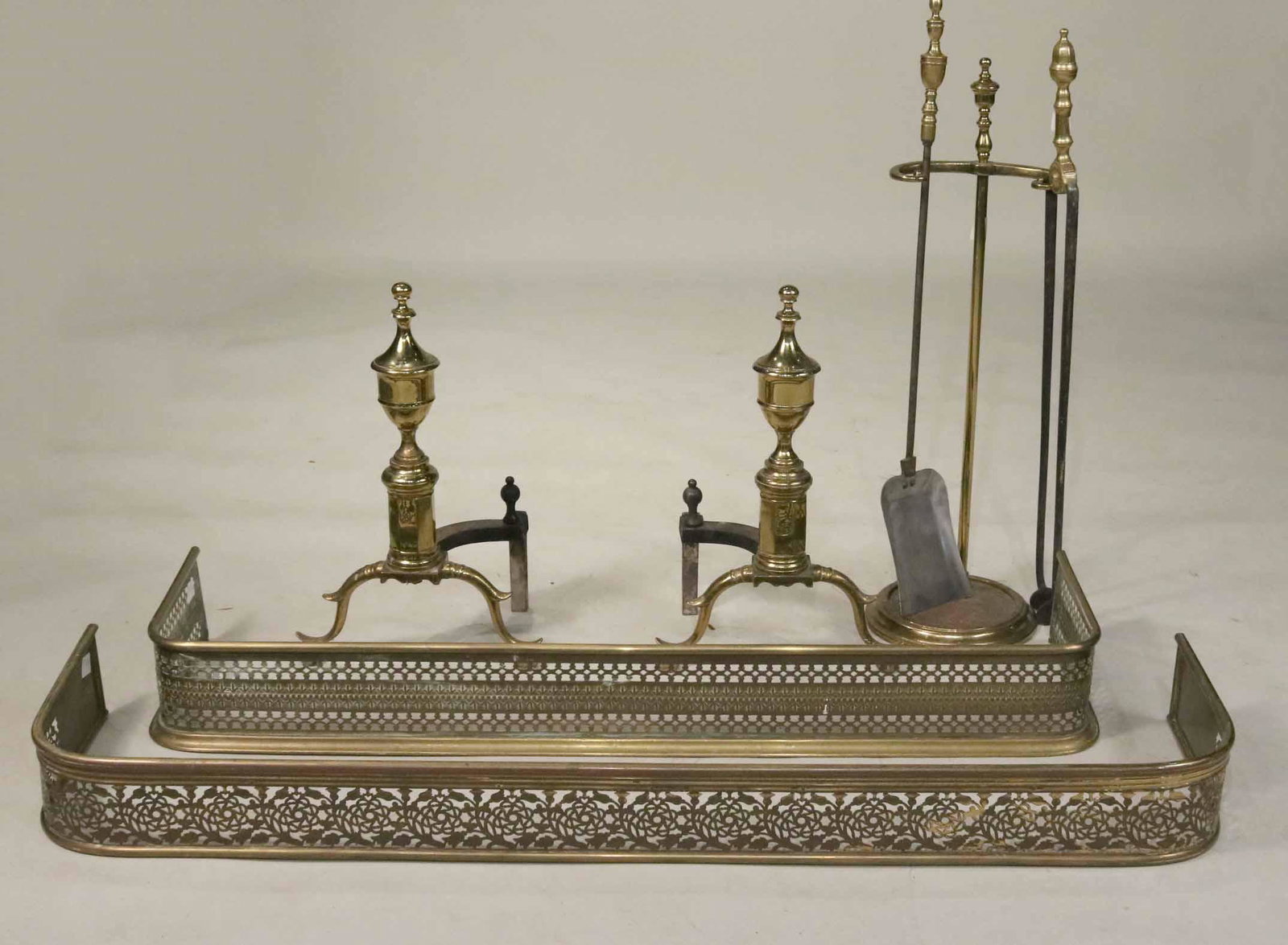 Two Federal Brass and Steel Fireplace Tools: American, 19th C., Comprising a shovel and tongs. Together with a pair of Federal style brass andirons, and two Regency pierced brass fenders and a tool stand. Tools: 34"h apx. Andirons: 21"h x 13-1/2